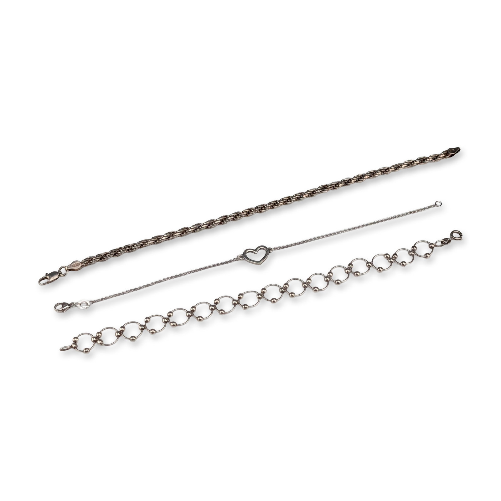 3pc Sterling Silver Bracelets: Trio of sterling silver bracelets in various styles. The collection includes one rope chain bracelet with a lobster claw clasp and end caps stamped 925 and ITALY. One James Avery link bracelet feature