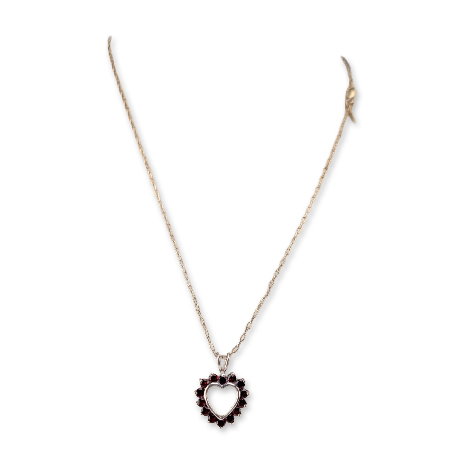 Sterling Silver and Garnet Heart Pendant Necklace: A pendant necklace featuring a heart-shaped sterling silver pendant set with round-cut garnets around an open-frame center. The pendant is suspended from a gold-toned flat-link cable chain with a lobs