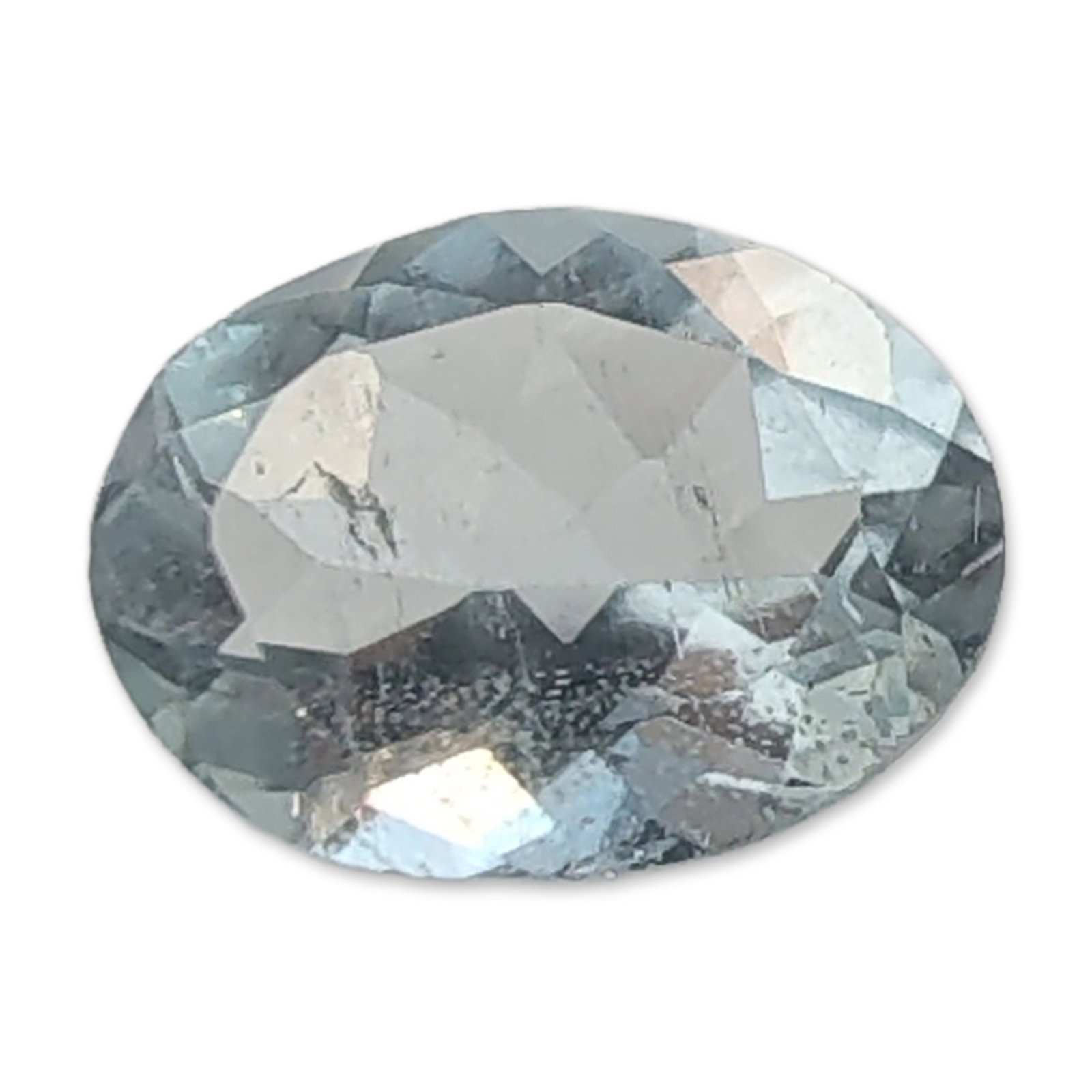 Faceted Oval Cut Light Blue Aquamarine Gemstone: Faceted oval cut light blue gemstone, appearing to be aquamarine. The stone features a pale, watery blue color and is fashioned in an oval brilliant cut. Visible internal inclusions and cloudiness
