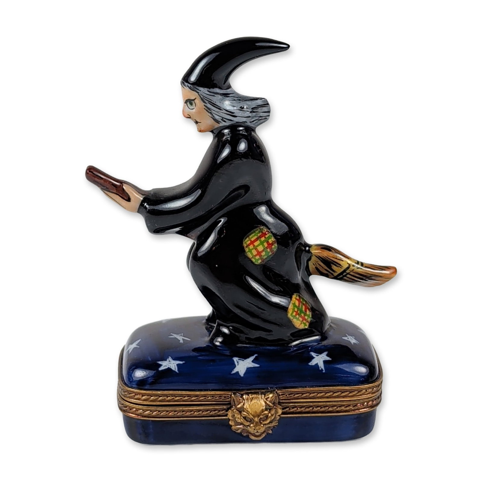 Rochard Limoges Witch Trinket Box: Rochard Limoges hand-painted porcelain trinket box featuring a witch in flight atop a broomstick. The figure is depicted in a black robe with red and green checkered patches and a pointed black hat. T