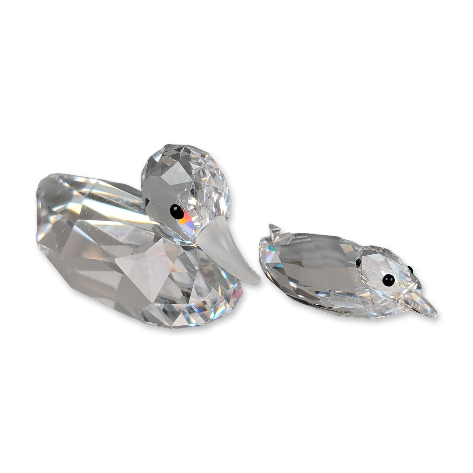 2pc Swarovski Crystal Duck Figurines: Two figurines in faceted clear lead crystal, depicting a swimming mother duck and a duckling. The larger figurine features a frosted crystal beak, and both are accented with inset black bead eyes.