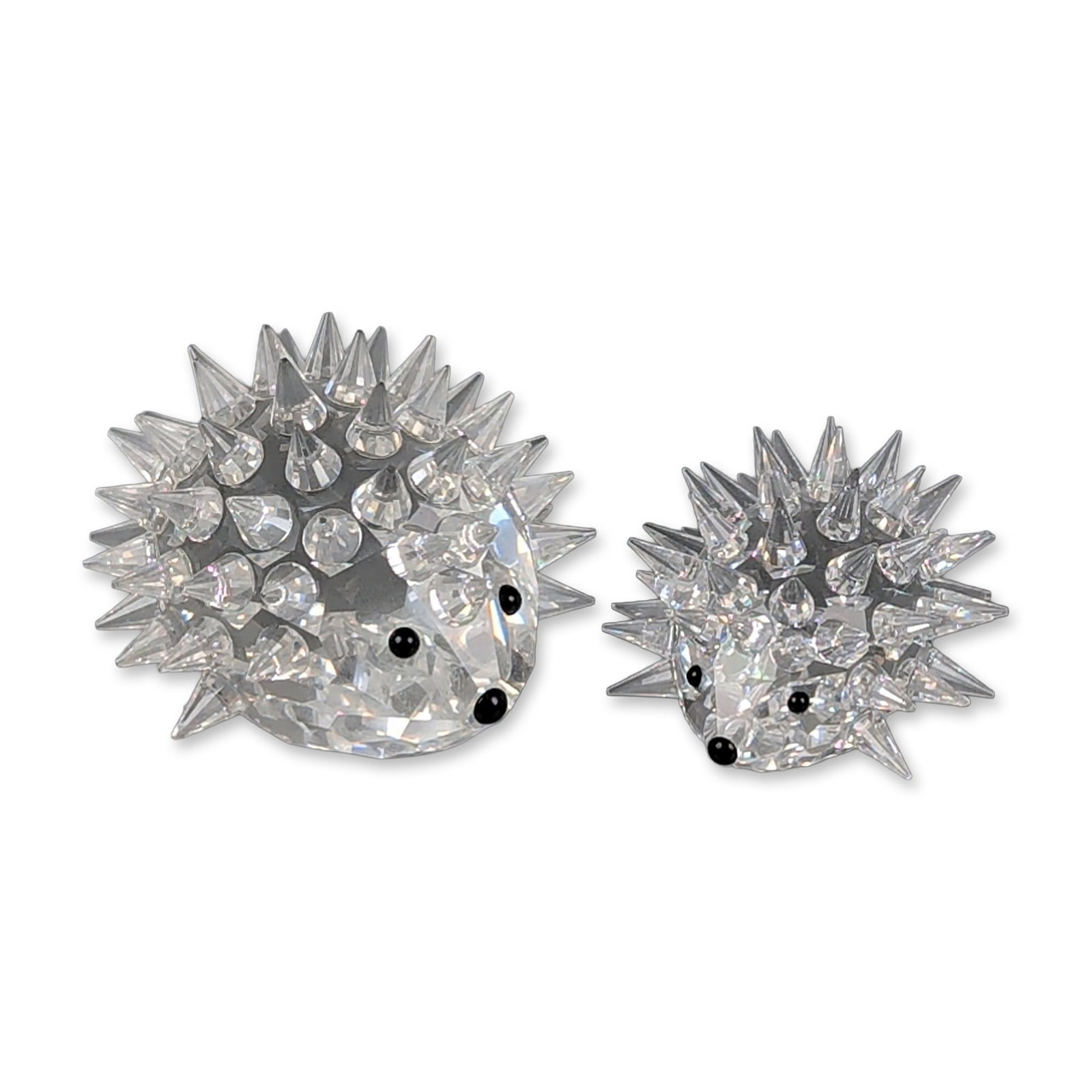 2pc Swarovski Clear Crystal Hedgehog Figurines: Two faceted clear lead crystal hedgehog figurines, featuring pointed crystal spikes and applied black crystal eyes and noses. Each figurine displays an etched mark consisting of a swan logo and the