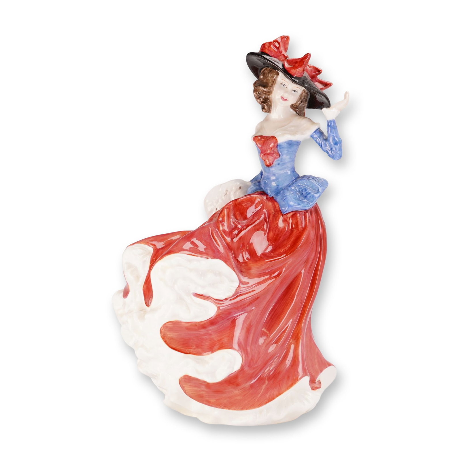 Royal Doulton Bone China Figurine, Janet HN4042: This hand-painted figure depicts a woman in a windswept pose, wearing a wide-brimmed black hat with red bows, a blue bodice, and a flowing red skirt with a white ruffled petticoat. She carries a white
