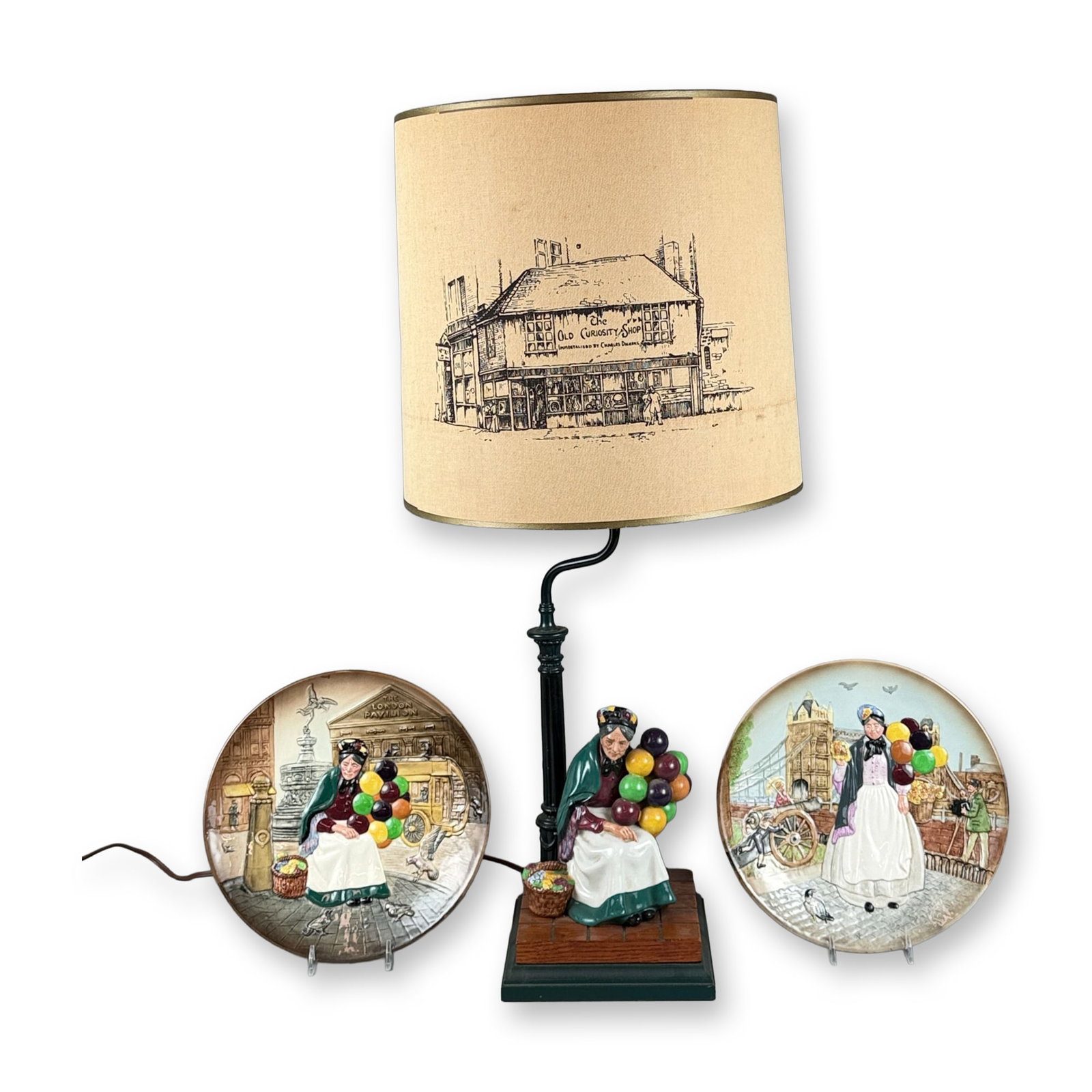 3pc Royal Doulton Porcelain Plates and Lamp with Shade: Collection of Royal Doulton collectibles comprising two polychrome relief-decorated plates and a table lamp. The plates depict The Old Balloon Seller (D6649) and Biddy Penny Farthing (D6666). Also