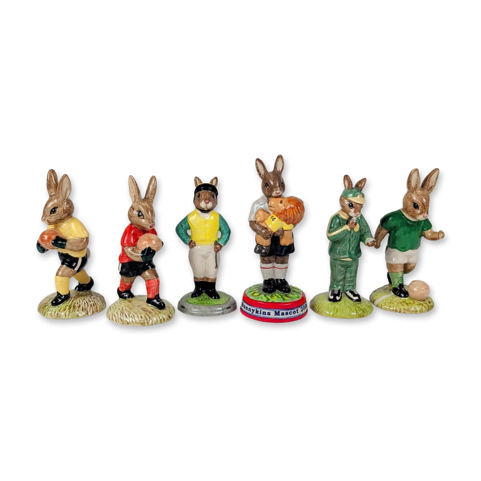 6pc Royal Doulton Bunnykins Sports Figurines: This six-piece collection of English ceramic figures from the Royal Doulton Bunnykins line features athletic-themed rabbit characters in polychrome glazes on textured grassy bases. The grouping consis