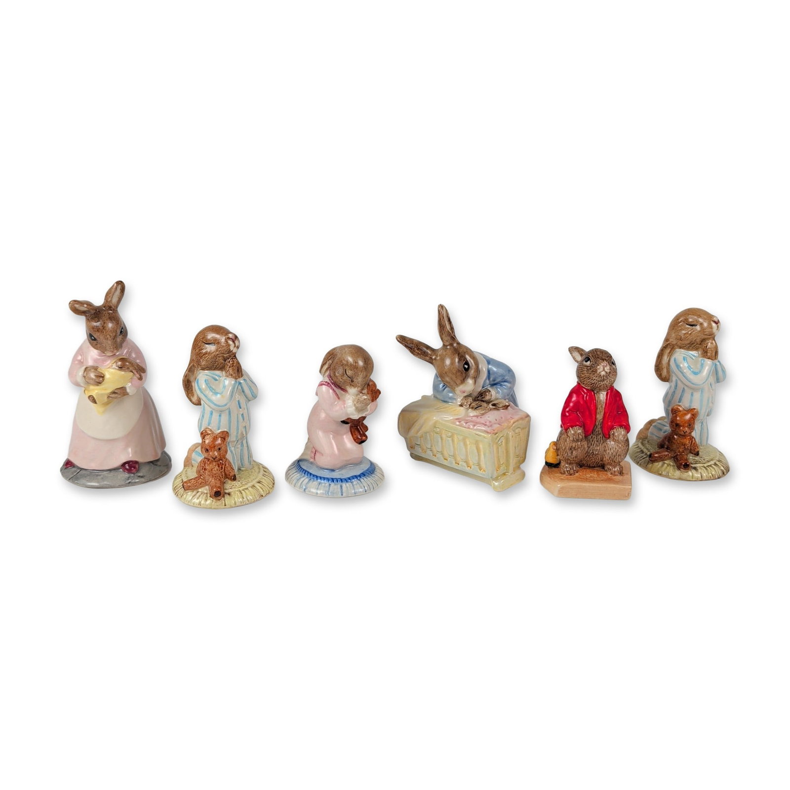 6pc Royal Doulton English Ceramic Bunnykins Figurines: This six-piece collection of English hand-painted glazed porcelain Bunnykins figures depicts anthropomorphic rabbits in various domestic and childhood settings. The grouping features Mother and Baby D