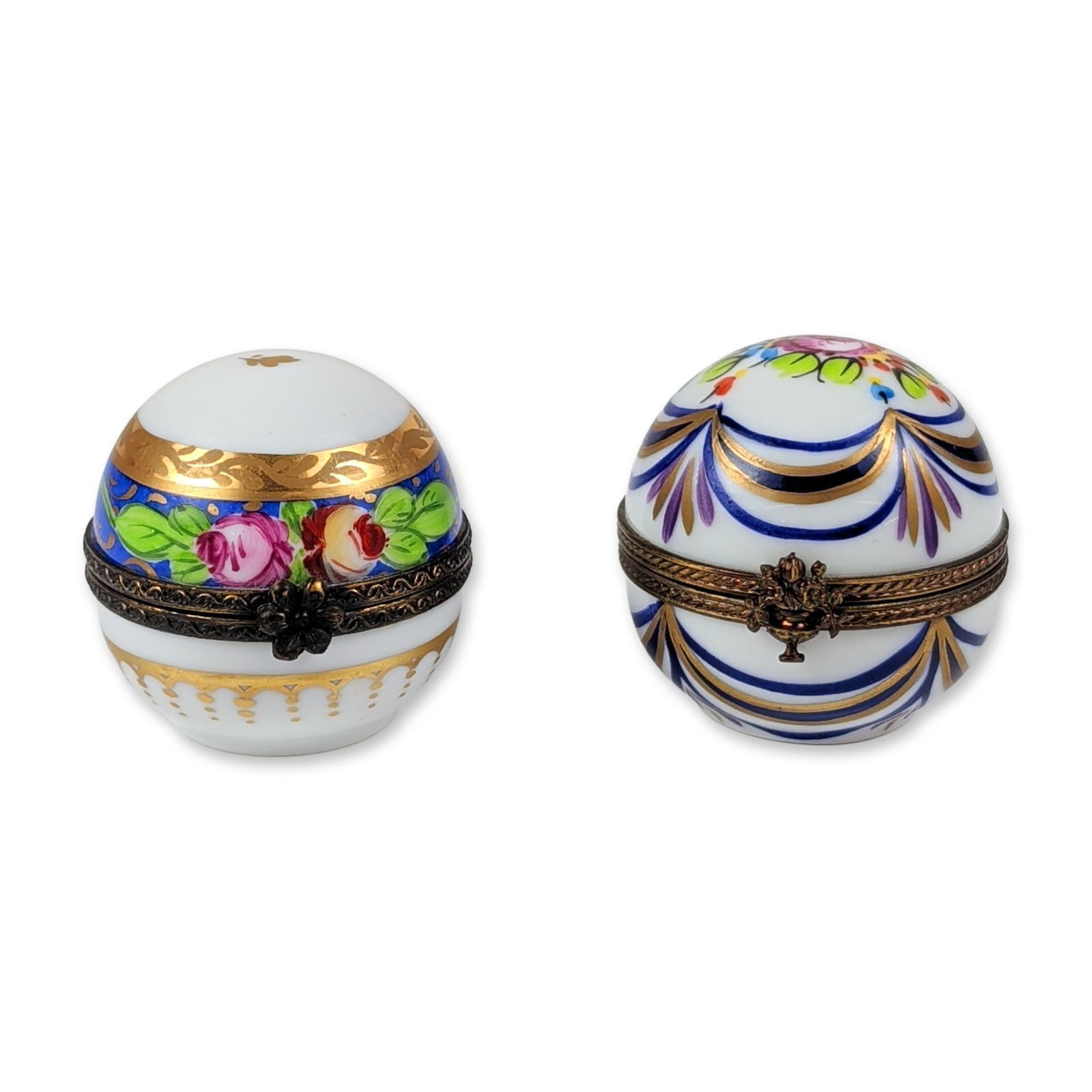 2pc Limoges France Hand Painted Porcelain Egg Boxes: This pair features two hand-painted Limoges porcelain egg-form boxes with decorative metal mounts and floral clasps. The first displays a band of pink and red roses on a cobalt blue ground with gilt b