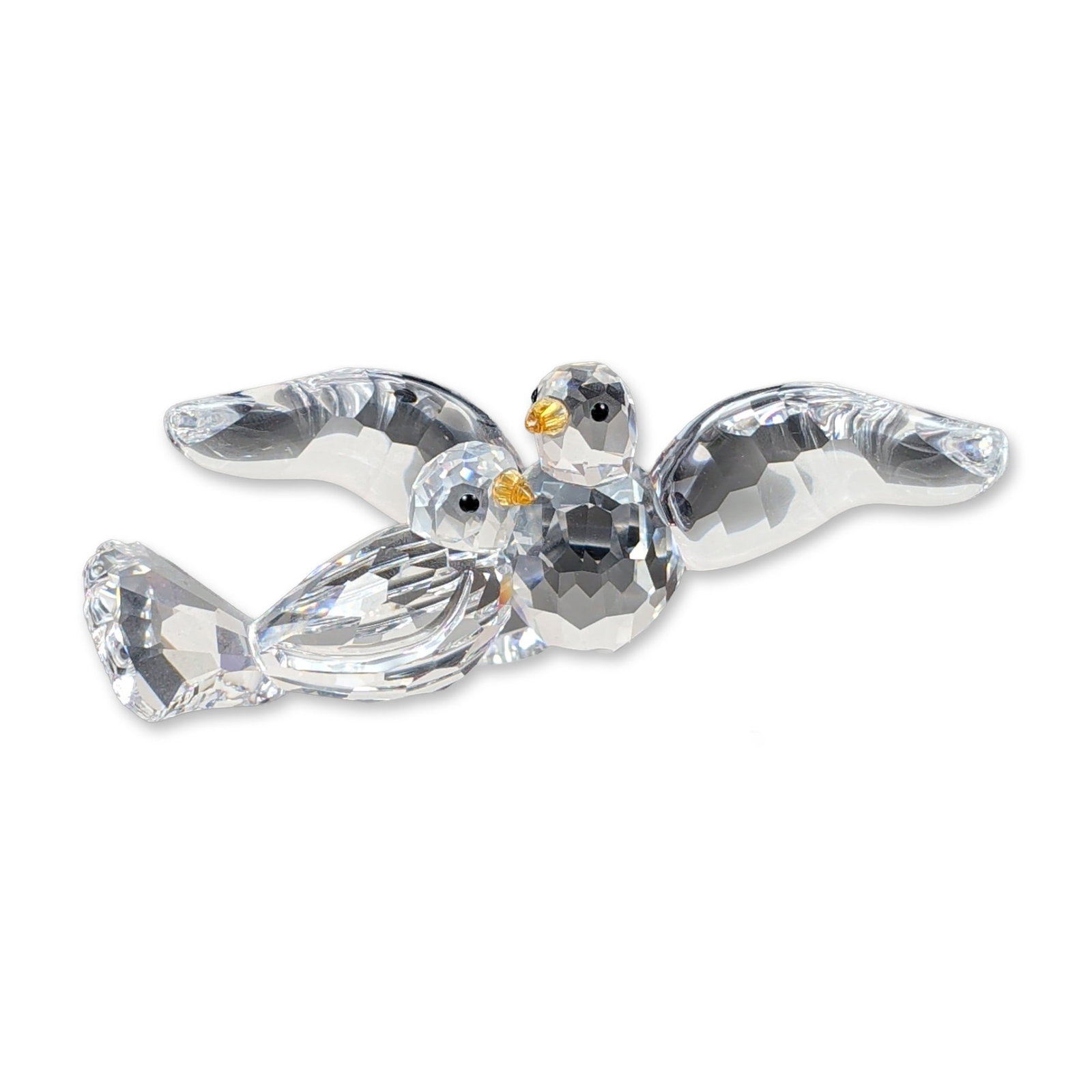 Swarovski Crystal Turtledoves Bird Figurine: Swarovski crystal figurine titled Turtledoves, featuring a pair of birds perched on a stylized branch. The birds are crafted from clear faceted crystal with small black inset eyes and yellow-orange be
