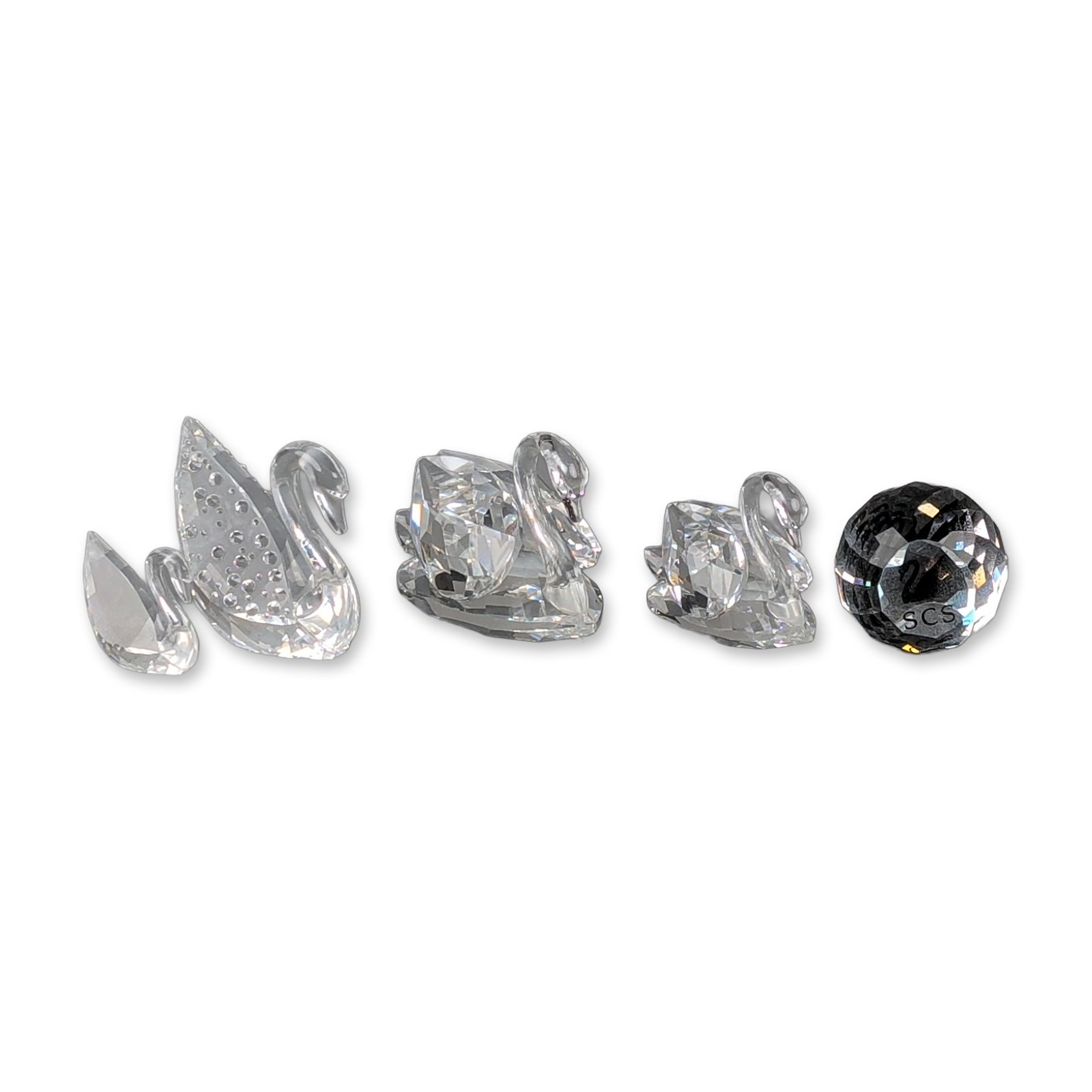 5pc Swarovski Lead Crystal Swan Figurines and SCS Paperweight: A collection of five faceted lead crystal figurines and collectibles. The group includes a 100th Anniversary Centenary Swan (1895-1995) featuring a smooth neck and wings decorated with a frosted circu