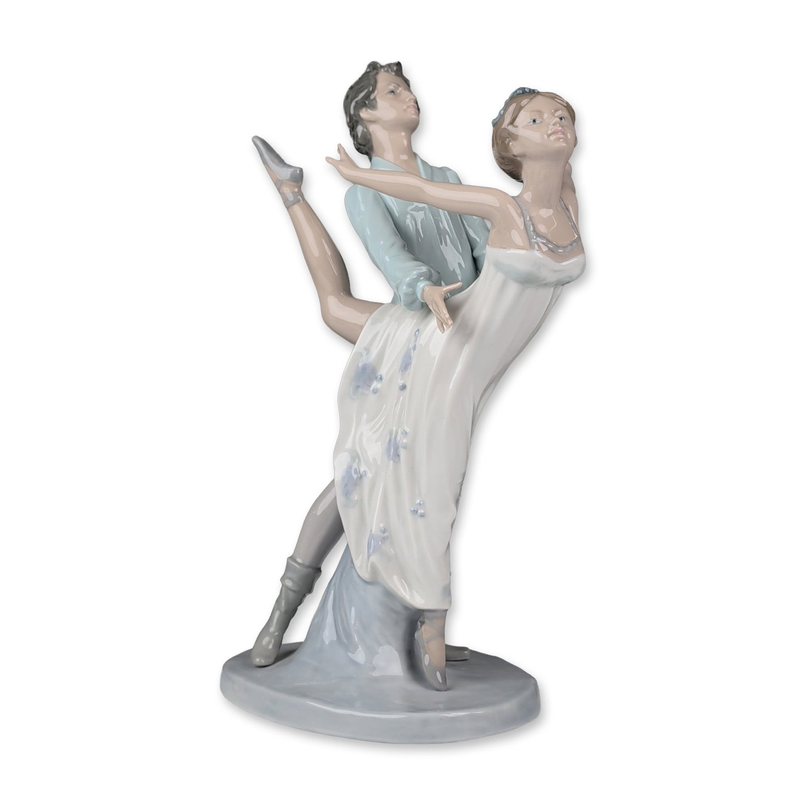 Nao by Lladro Porcelain Figurine, Dancing on a Cloud: Depicting a male and female ballet dancing couple in a dynamic pas de deux pose. The male dancer is attired in a light blue tunic with puffed sleeves and grey tights, shown supporting the female dance