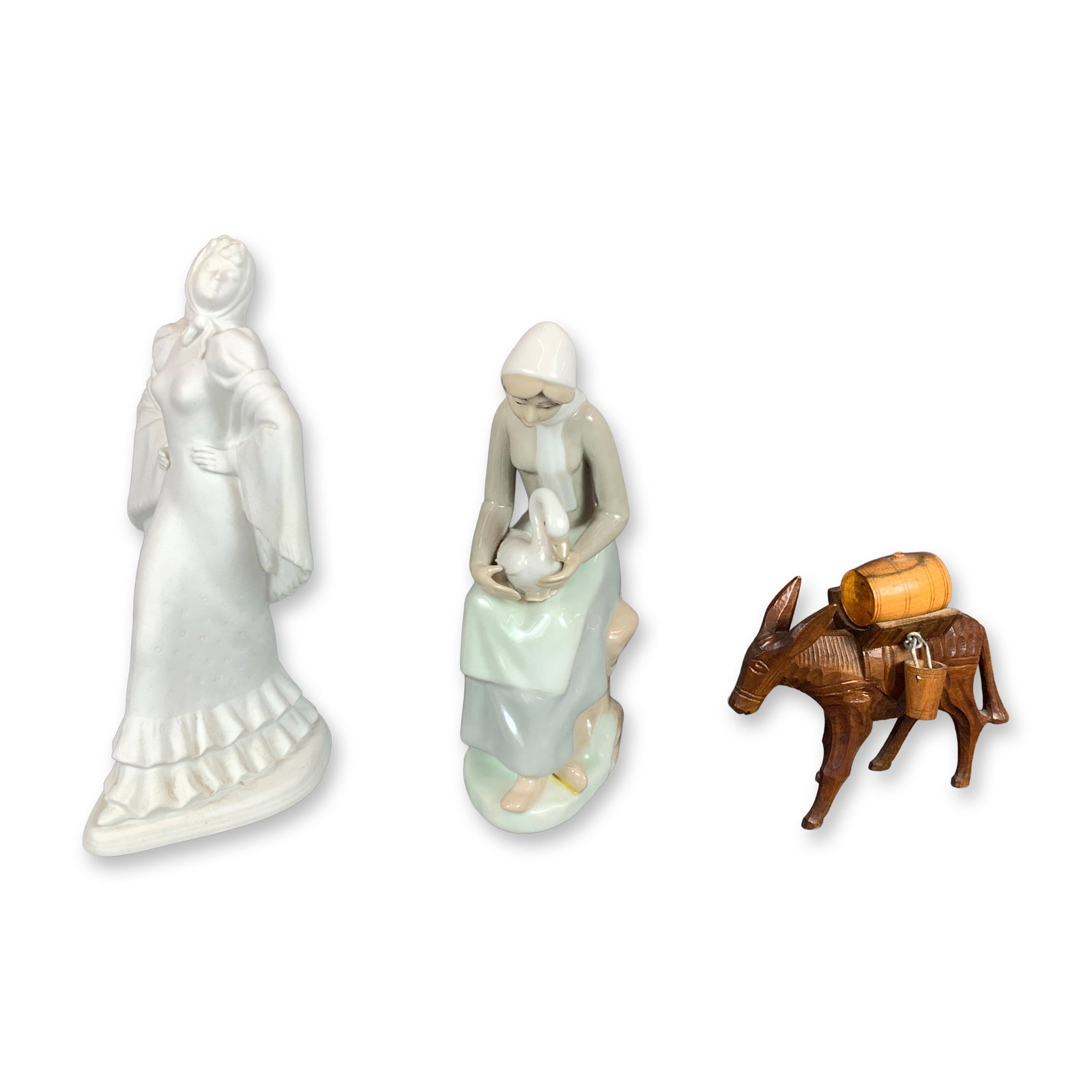 3pc Porcelain and Wood Figurines: This collection includes three decorative figurines. The first is a standing Spanish woman figurine made of white bisque porcelain. The figure is draped in a shawl and traditional dress. The underside