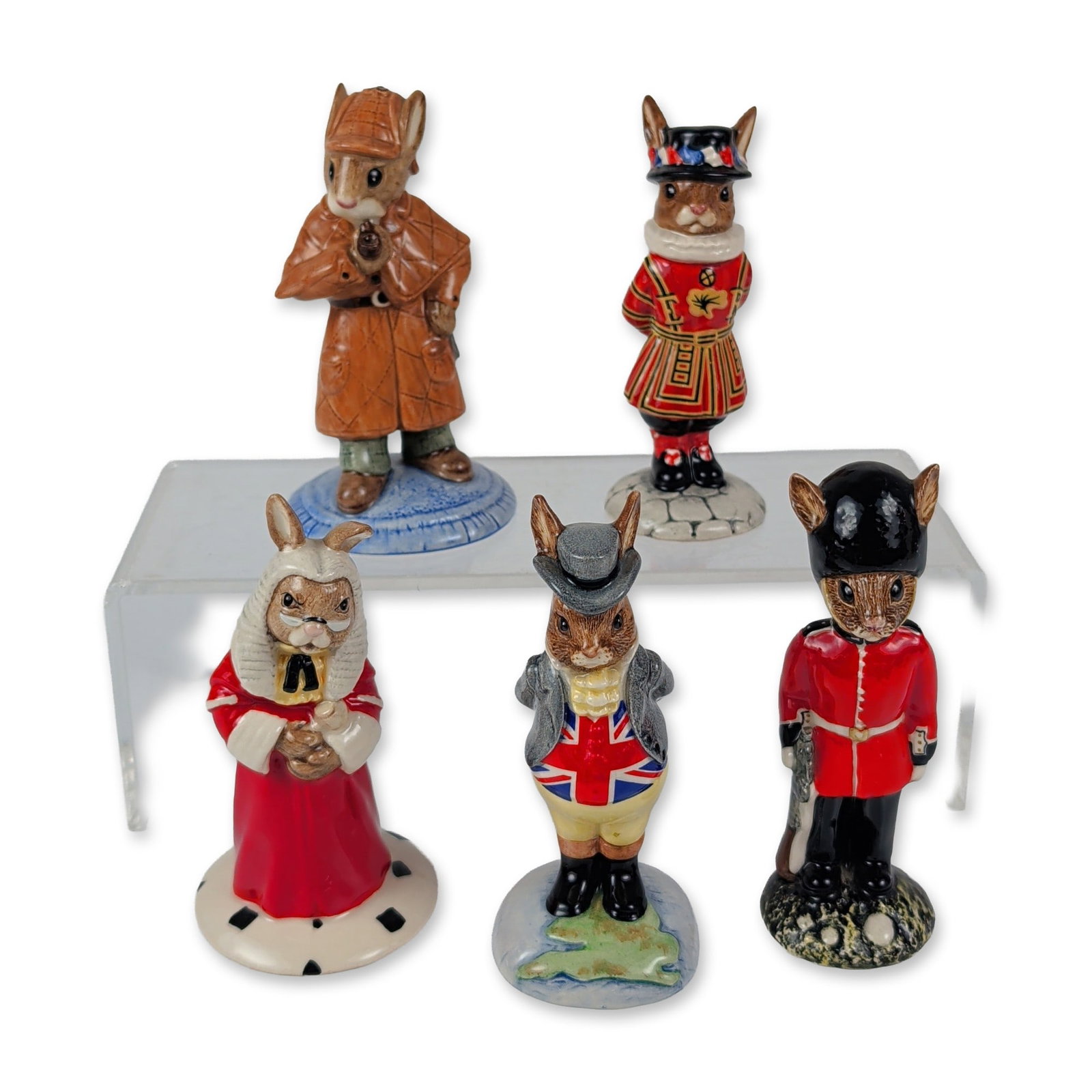 5pc Royal Doulton Bunnykins Figurines: This five-piece collection of English glazed ceramic Bunnykins figures showcases anthropomorphic rabbits in traditional British-themed attire and historical character costumes. The regional grouping f