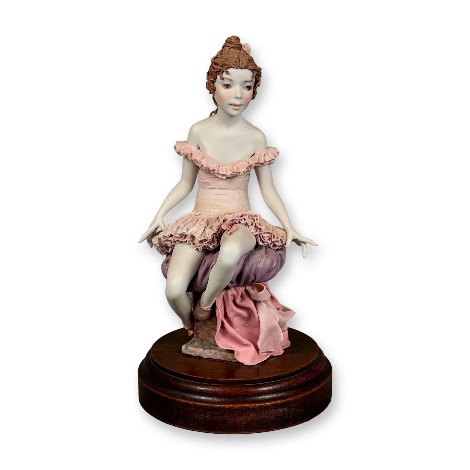 Bonni Porter Signed and Numbered Porcelain Ballerina Figure on Wooden Base: A hand-painted bisque porcelain figurine of a seated ballerina by American artist Bonni Porter. The figure is depicted in a seated pose atop a sculpted base designed to resemble draped purple and pink