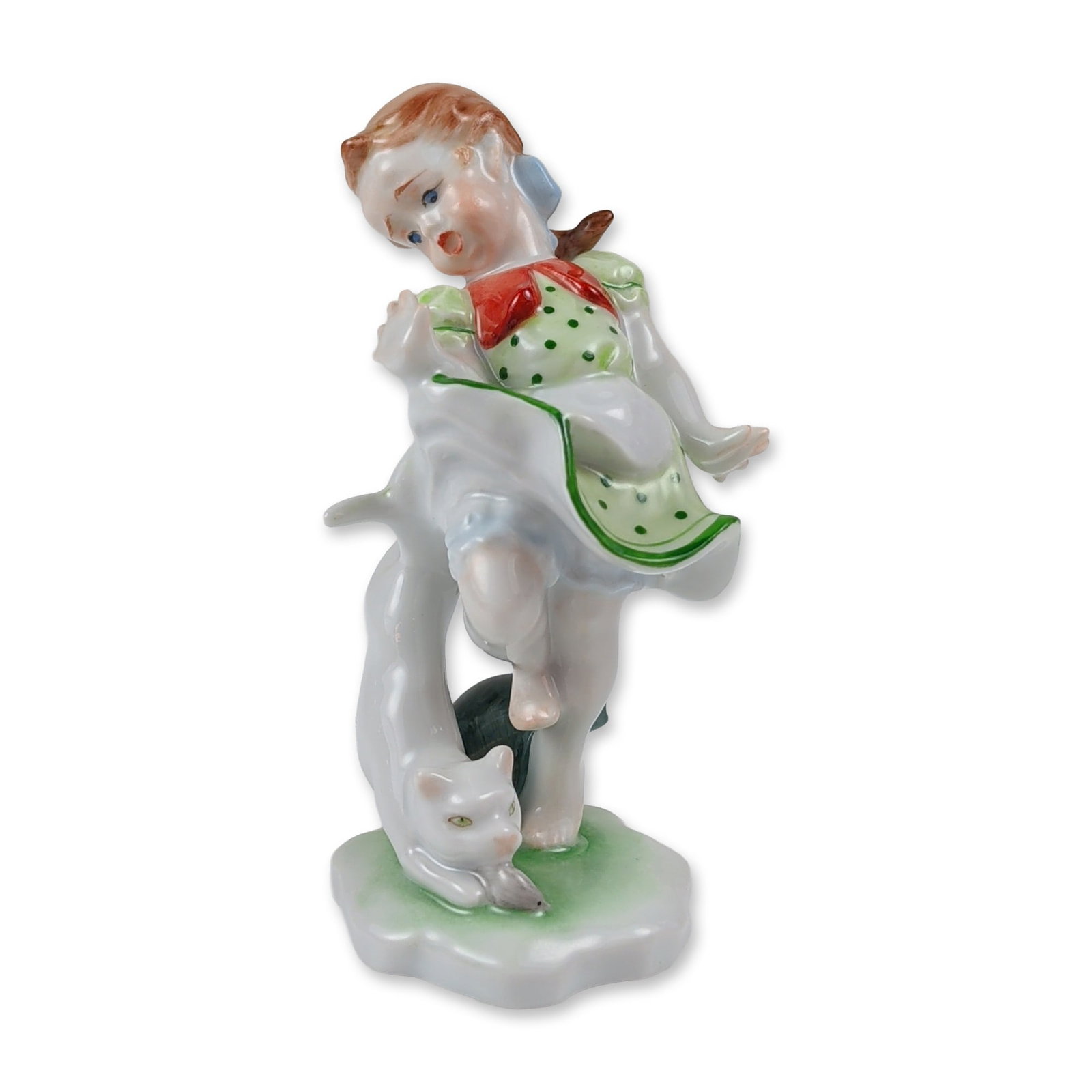 Herend Hungarian Hand-Painted Porcelain Girl and Cat Figurine: A Herend hand-painted fine porcelain genre figurine depicting a young girl modeled in traditional Hungarian folk attire, sporting a light green polka-dot dress with a matching apron, a red bow at the 