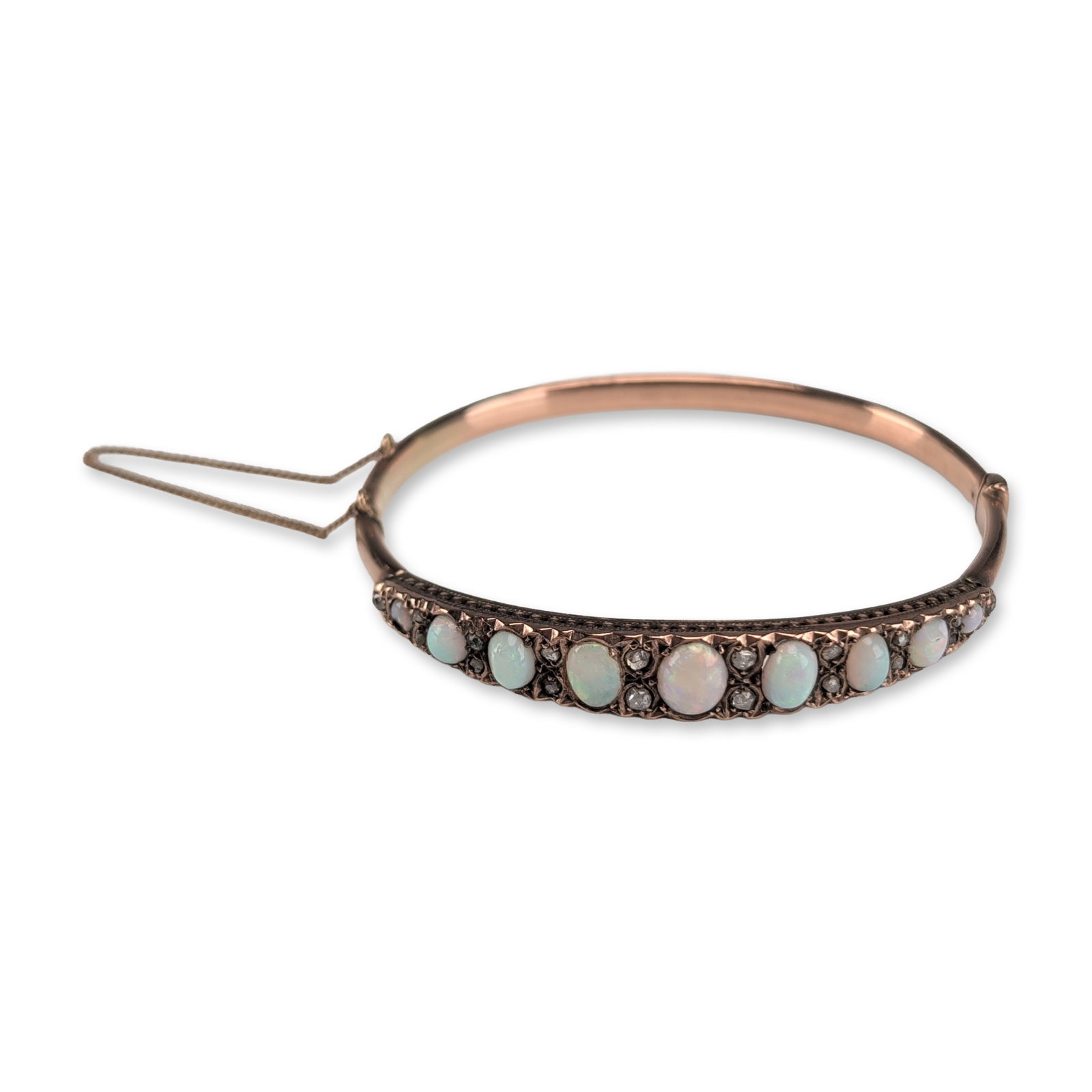 Antique Victorian 10K Rose Gold Opal and Diamond Bangle Bracelet: Antique Victorian hinged bangle bracelet crafted in 10K rose gold. The front face features a graduated row of nine oval cabochon opals, which display a play-of-color including flashes of green, blue, 