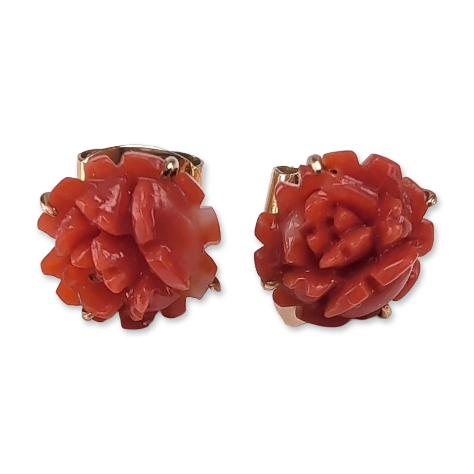 18K Yellow Gold Carved Coral Flower Stud Earrings: Pair of stud earrings in 18K yellow gold, featuring carved red coral in a rose flower motif. Each coral element is held by a four-prong setting on a gold mount with post and butterfly backs. Stamped 1