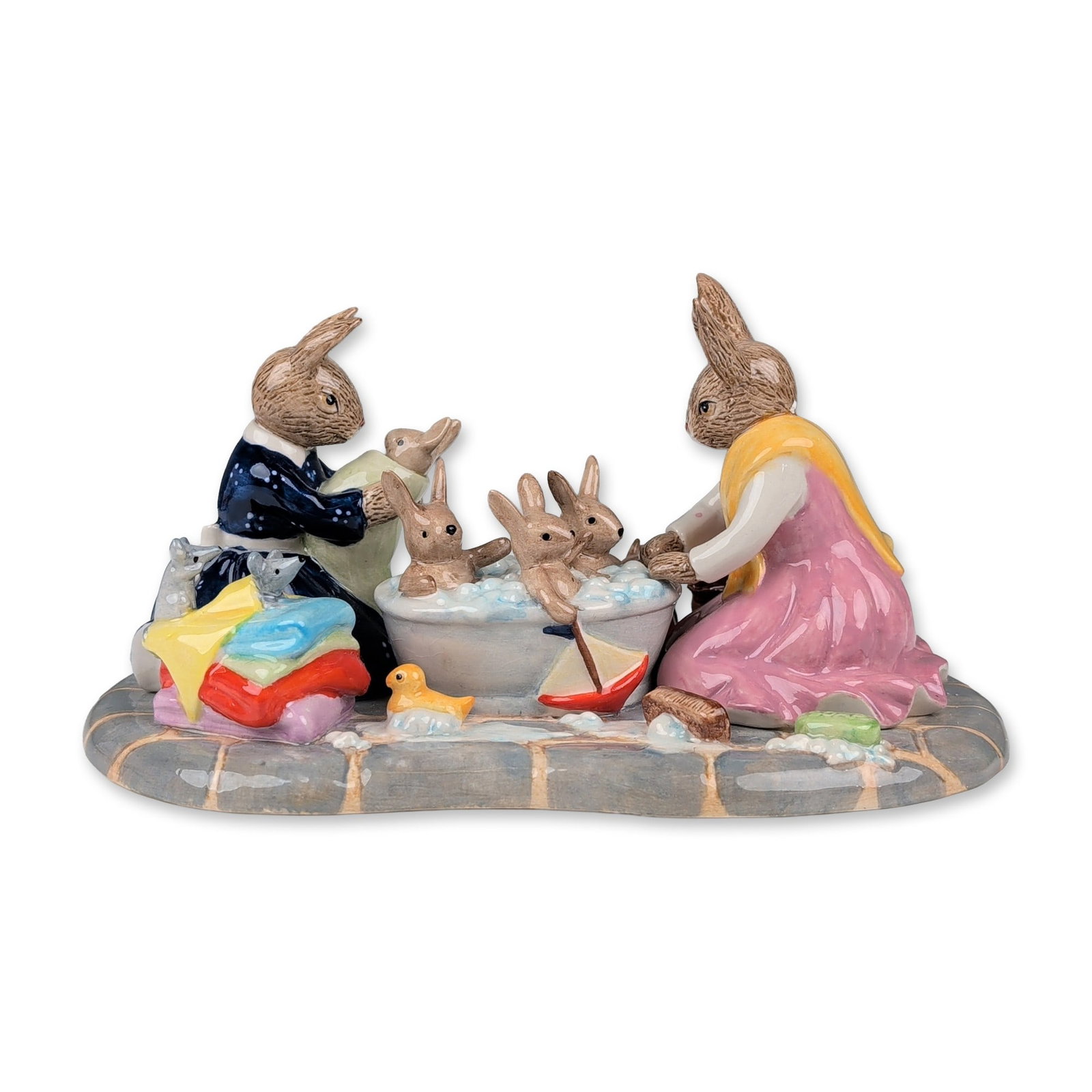 Royal Doulton Bunnykins Figurine, Bathtime DB483: This limited edition 331 of 400 Bunnykins tableau depicts two adult rabbits bathing baby rabbits in a washbasin. The scene is set on a cobblestone-style base and features a side table with a blue and 
