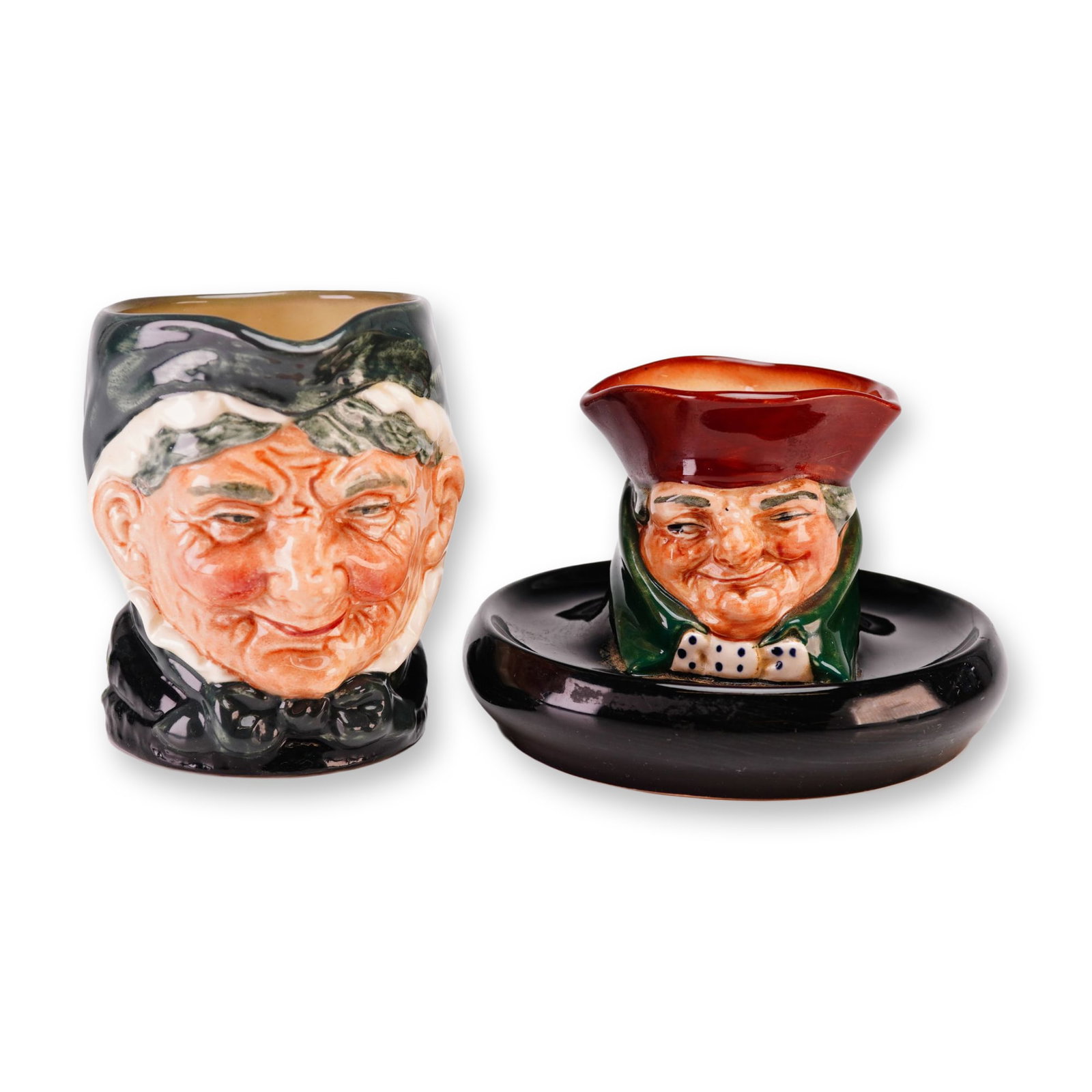 Royal Doulton Granny and Old Charley Character Ware Grouping: This 2pc Royal Doulton grouping includes an Old Charley ashtray and a Granny small jug. Produced by Royal Doulton in Burslem, England, these glazed earthenware items feature molded character forms dec
