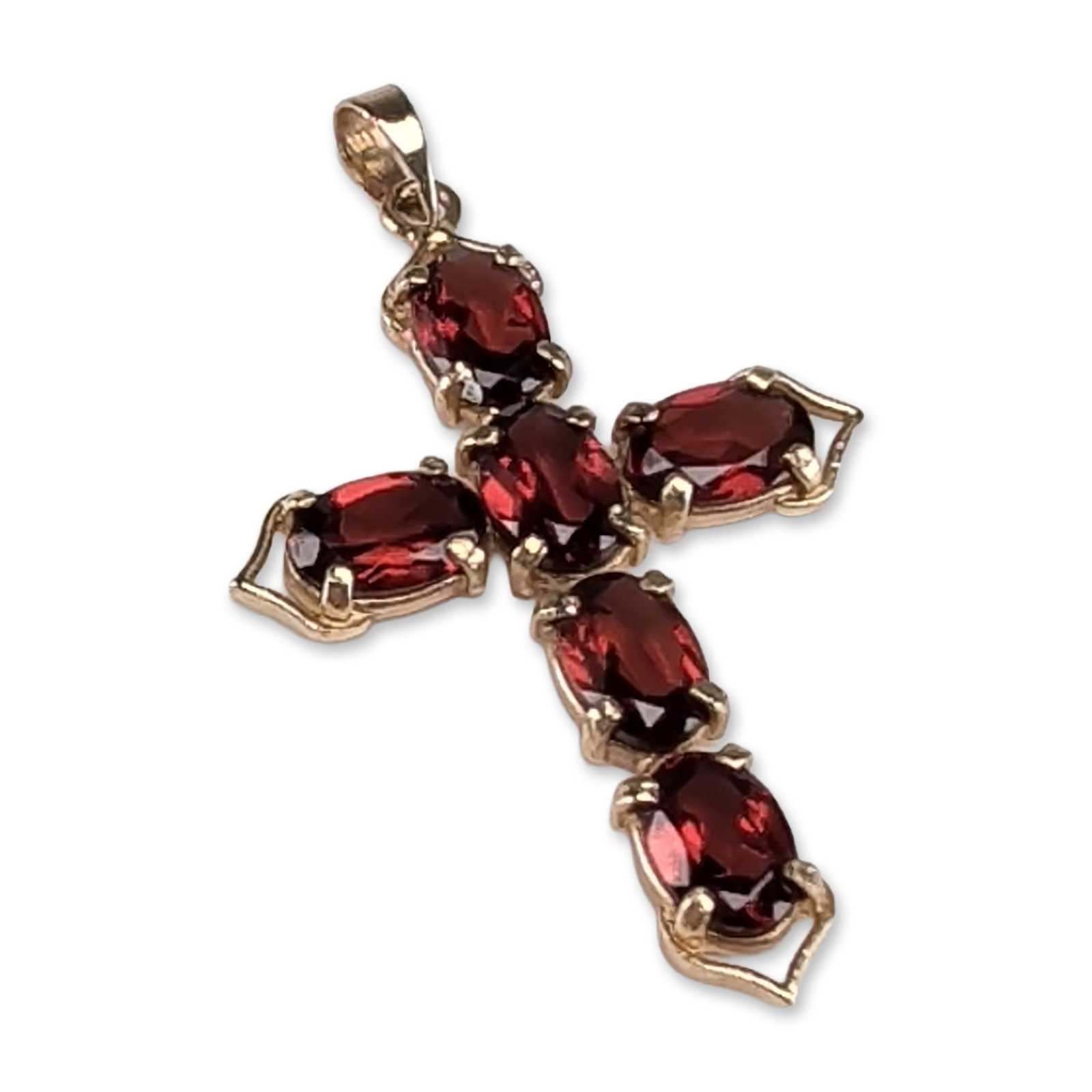 14K Yellow Gold and Garnet Cross Pendant: A 14k yellow gold cross pendant featuring six prong-set, oval-faceted deep red garnets arranged in a cruciform pattern. Each arm of the cross terminates in a stylized, pointed gold scroll accent. The