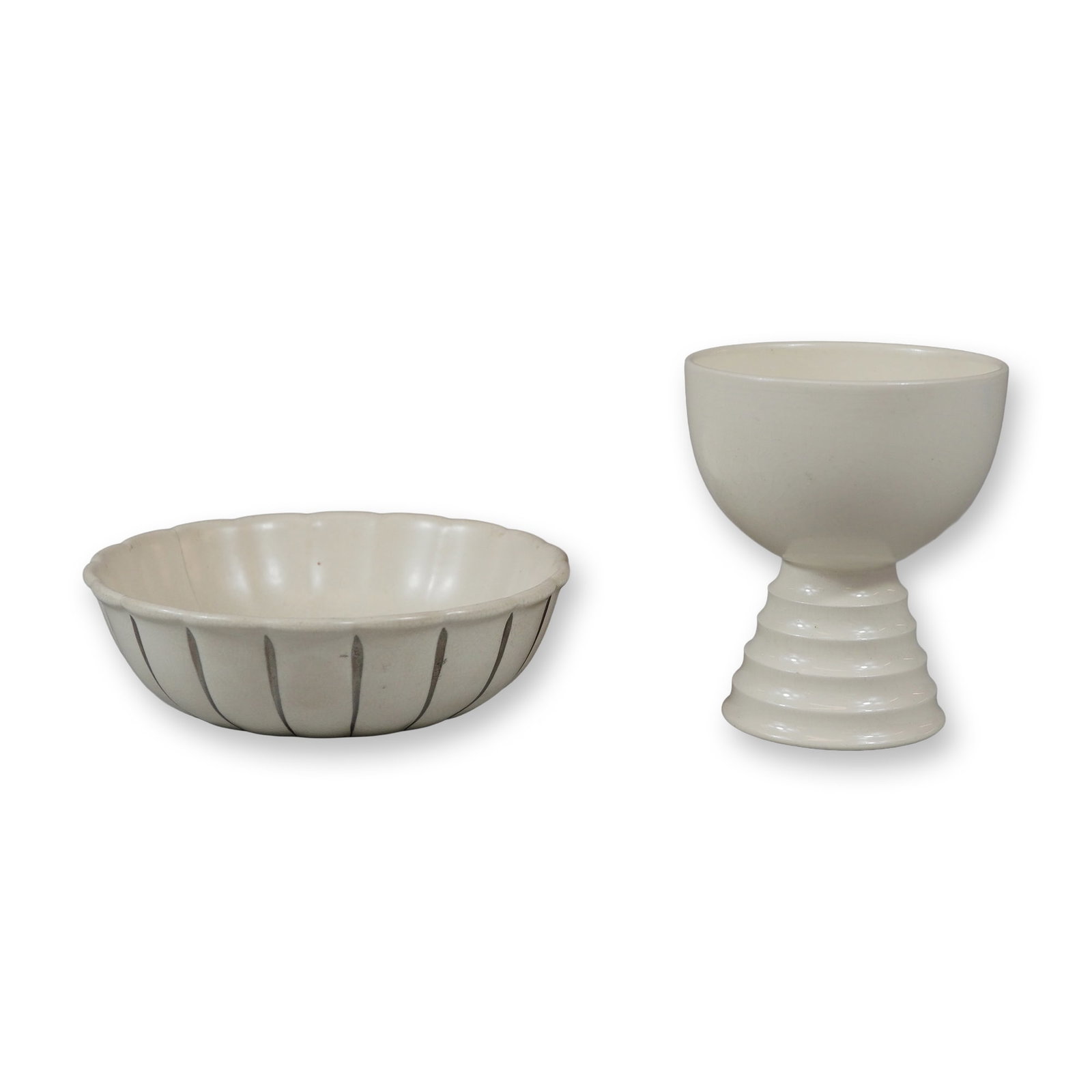 Two Wedgwood by Keith Murray Cream Earthenware Dish and Egg Cup: The first item is a circular bowl with a scalloped rim and a fluted exterior. It is decorated with hand-painted vertical dark gray lines within the fluted channels. The base of the bowl is marked