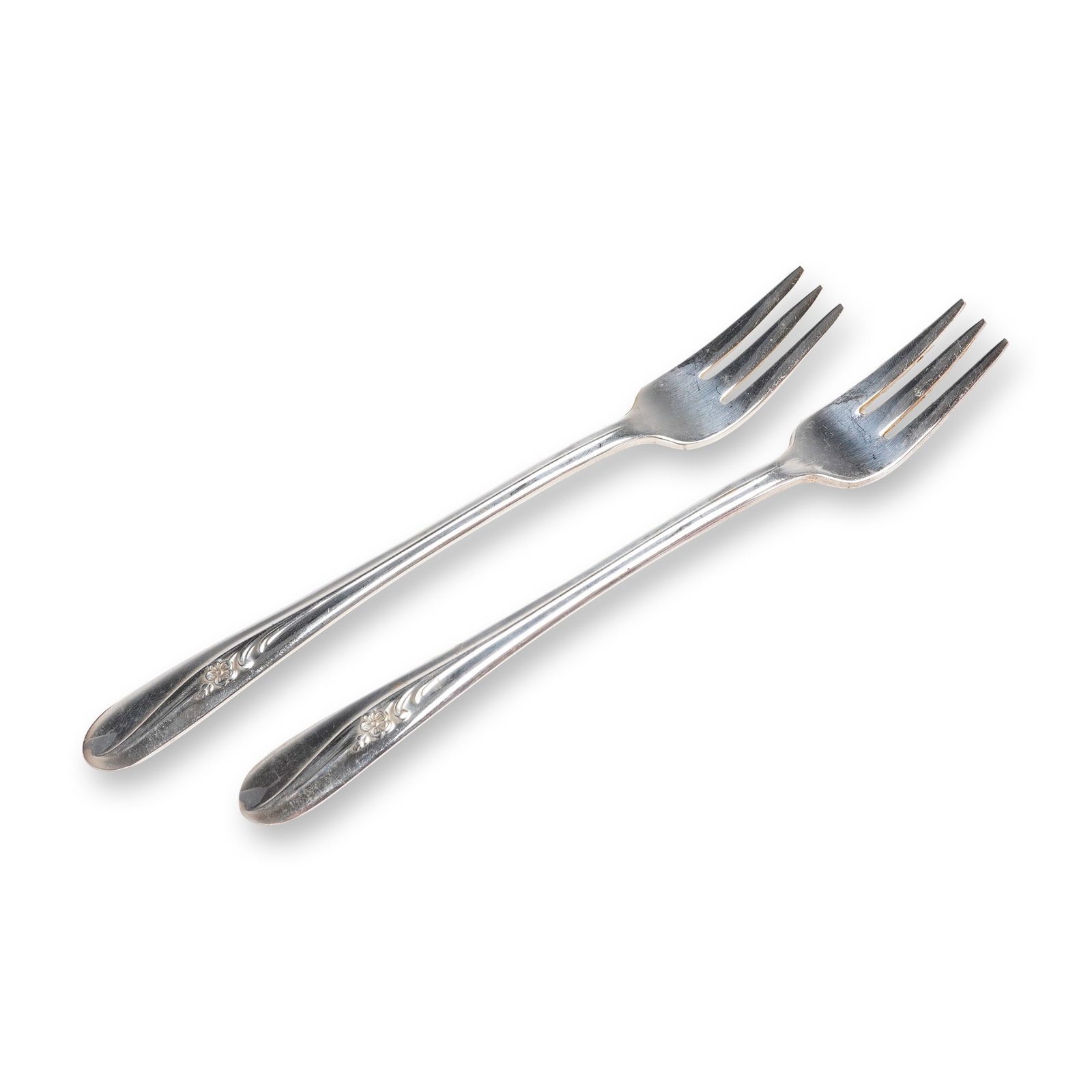 A Pair of Holmes & Tuttle Silverplate Meadow Flower Pattern Forks: A pair of silverplate dining forks by Holmes & Tuttle (H. & T. MFG. CO.) in the Meadow Flower pattern, dating to approximately 1940. This 2pc lot consists of two matching four-tine dining fork