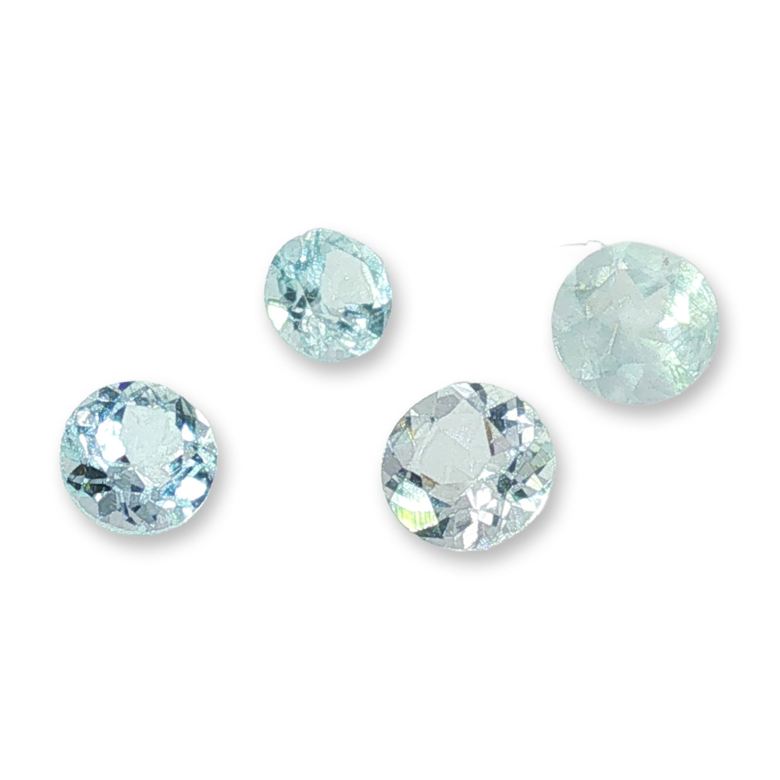 A Set of Four Round Cut Aquamarine Gemstones: A set of four loose faceted gemstones in aquamarine, featuring round brilliant-cut faceting. The stones exhibit a pale, watery blue color and appear to be natural material with visible internal inclus