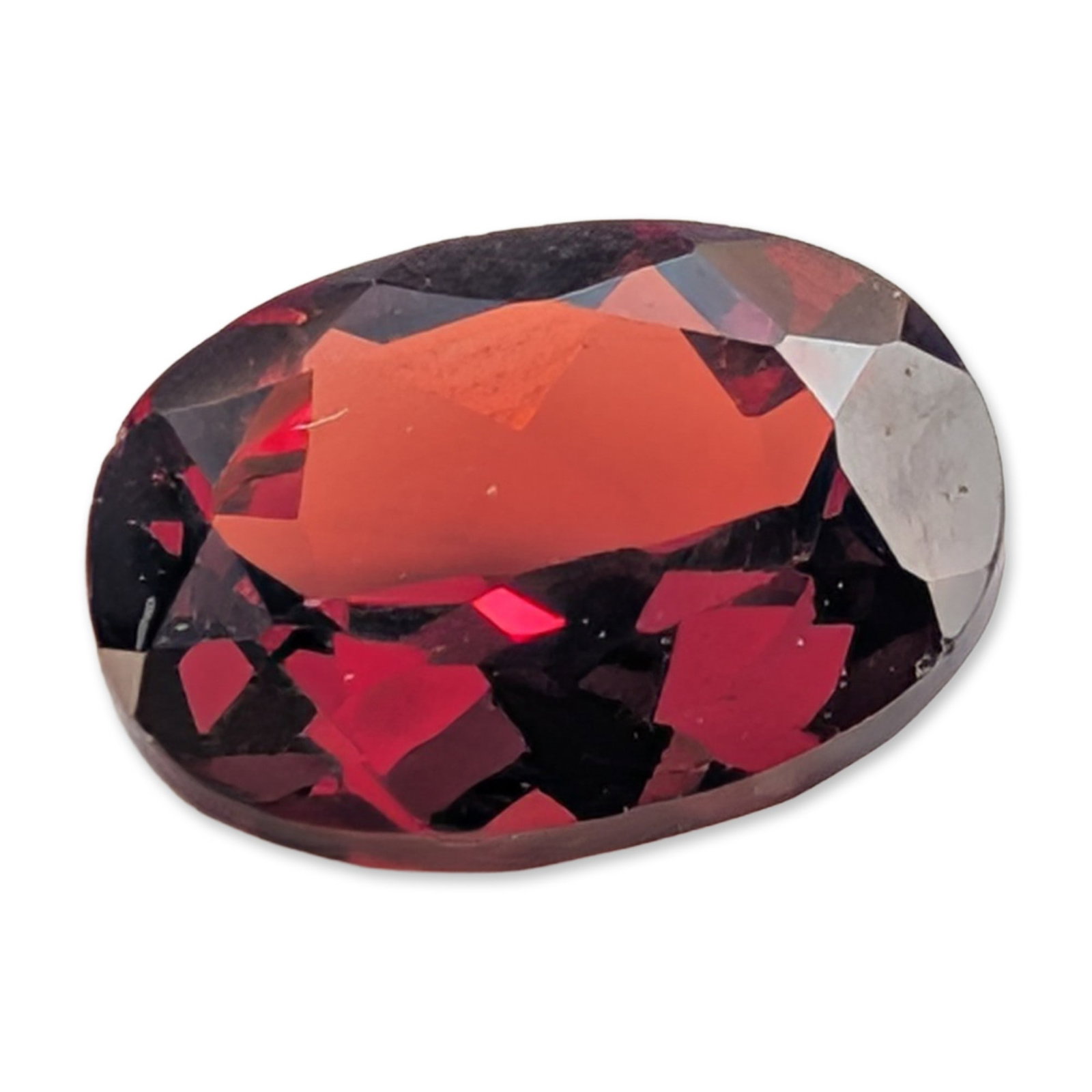 Oval Mixed Cut Red Almandine Garnet Gemstone: Single loose gemstone, appears to be an almandine garnet, featuring a saturated deep red oxblood hue with secondary orange-red flashes. The stone is presented in an oval mixed cut, incorporating a bri