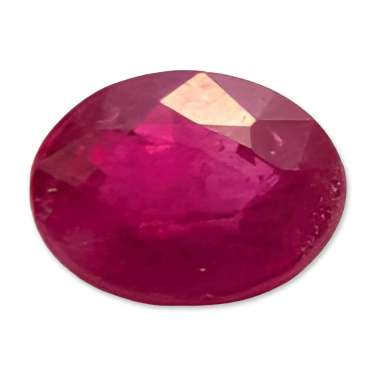 Oval Mixed Cut Pinkish-Red Loose Ruby Gemstone: Loose faceted ruby gemstone. The stone displays a pinkish-red color in an oval mixed cut, featuring visible internal feathers and a dark mineral inclusion. 0.6ct Dimensions: 5 mm W
