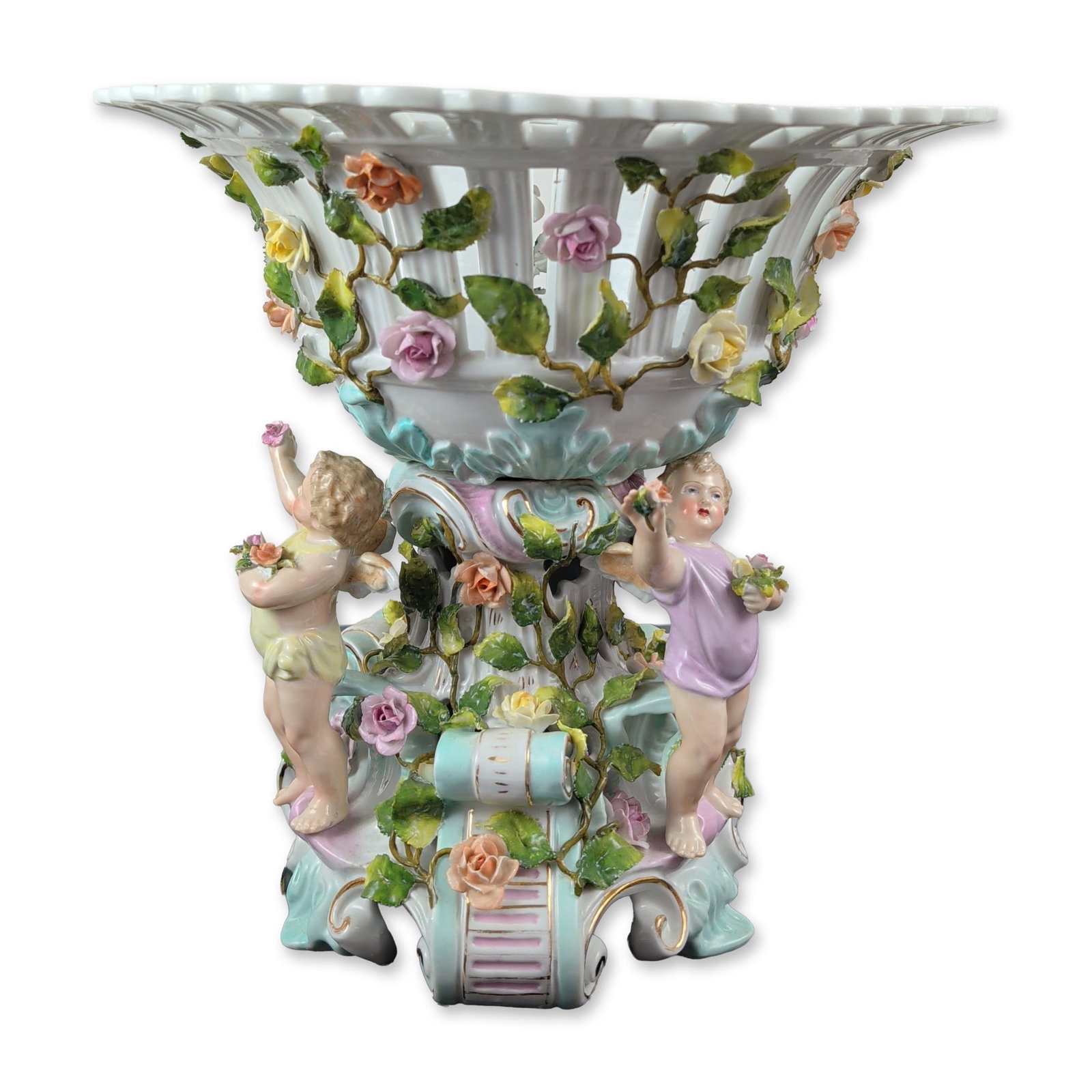 Antique German Schierholz Encrusted Porcelain Cherub Centerpiece: Centerpiece in encrusted porcelain, featuring a two-part construction. The flared lattice-work basket with a scalloped rim sits atop a pedestal base modeled with three cherub figures, each wearing a p