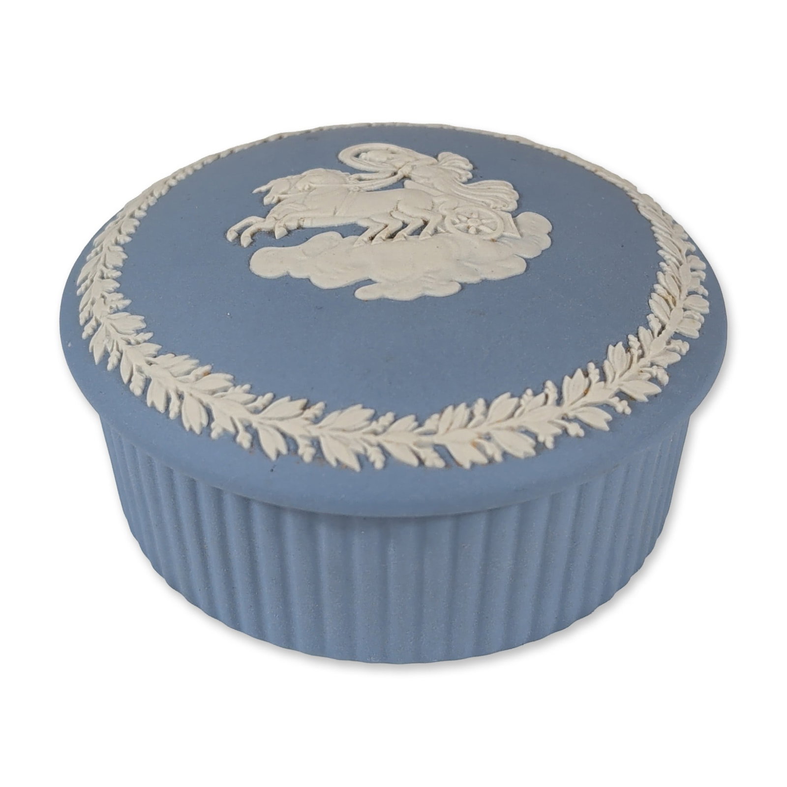Wedgwood Blue Jasperware Treasure Box: Wedgwood. Round lidded trinket box in pale blue jasperware, featuring white bas-relief classical decoration. The lid depicts a horse and chariot scene within a laurel wreath border. The exterior body 