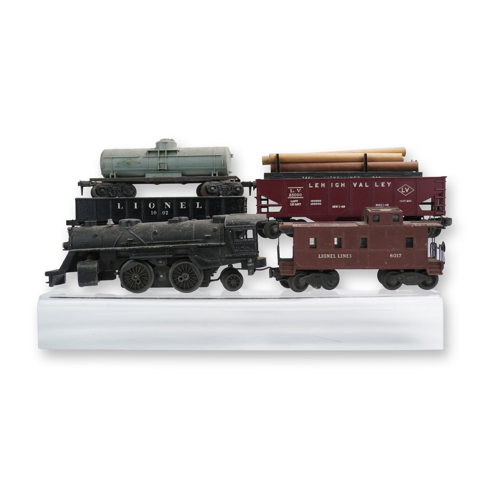 6pc Lionel Postwar O/O-27 Gauge Model Train Components: A collection of five Lionel Postwar O/O-27 gauge model train components, constructed from die-cast metal and composite plastic. The lot includes a black steam locomotive, a pale green tank car, a blac