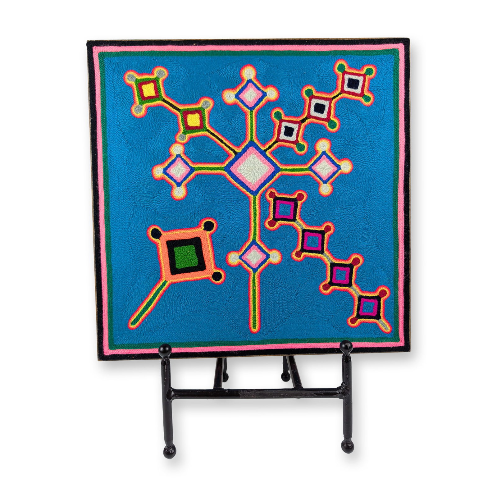 Huichol Mexican Folk Art Ojo de Dios Nierika Yarn Painting: This traditional square Mexican folk art yarn painting is constructed with colored commercial yarn pressed onto a particle board substrate. The geometric composition features a central Ojo de Dios (Ey