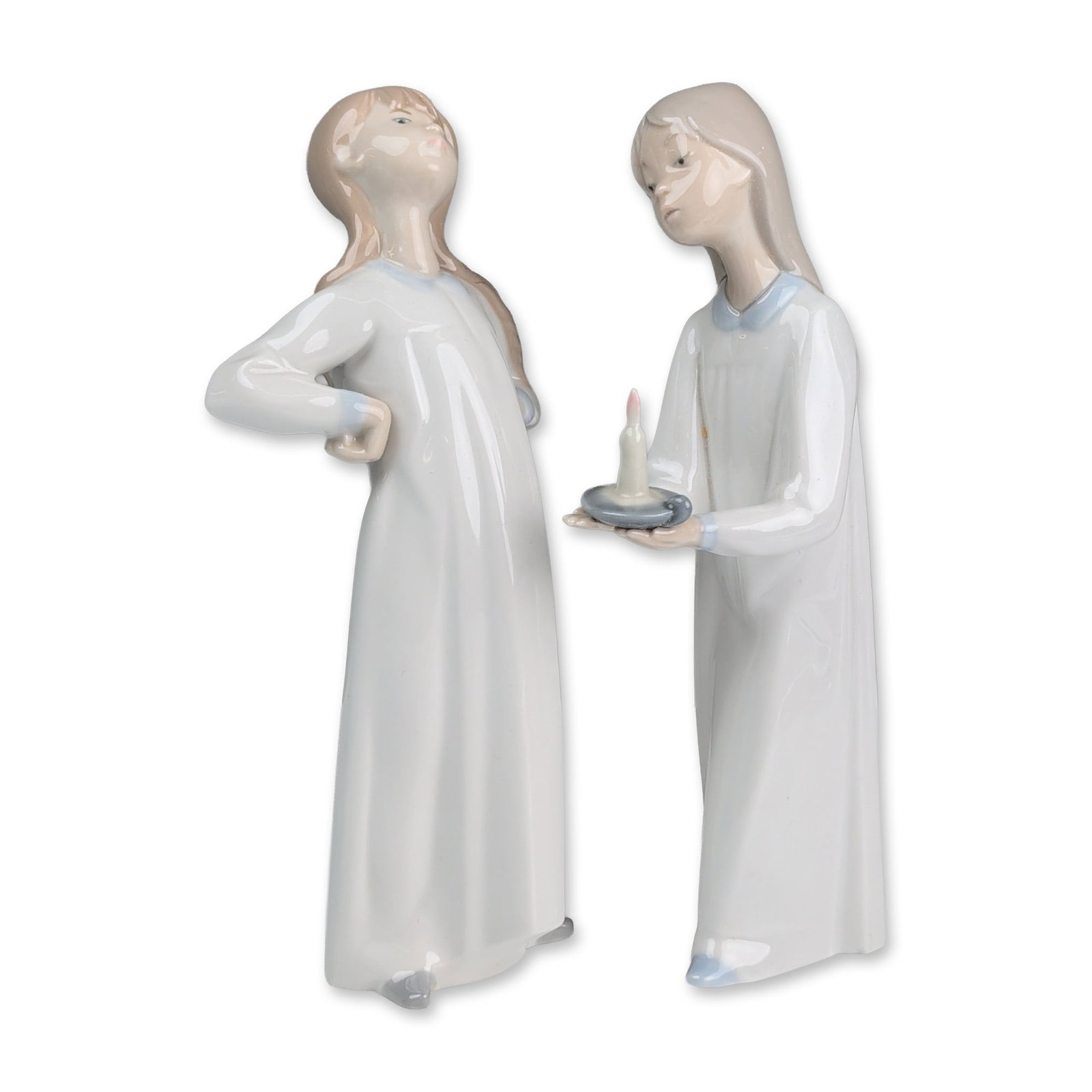 2pc Lladro Glazed Porcelain Figurines, Girl with Candle 01006233 and Girl Stretching 01004872: Porcelain figurines featuring young girls in nightgowns. The grouping includes one girl holding a chamber stick with a pink candle and one girl standing with hands behind her back. Both pieces are fin