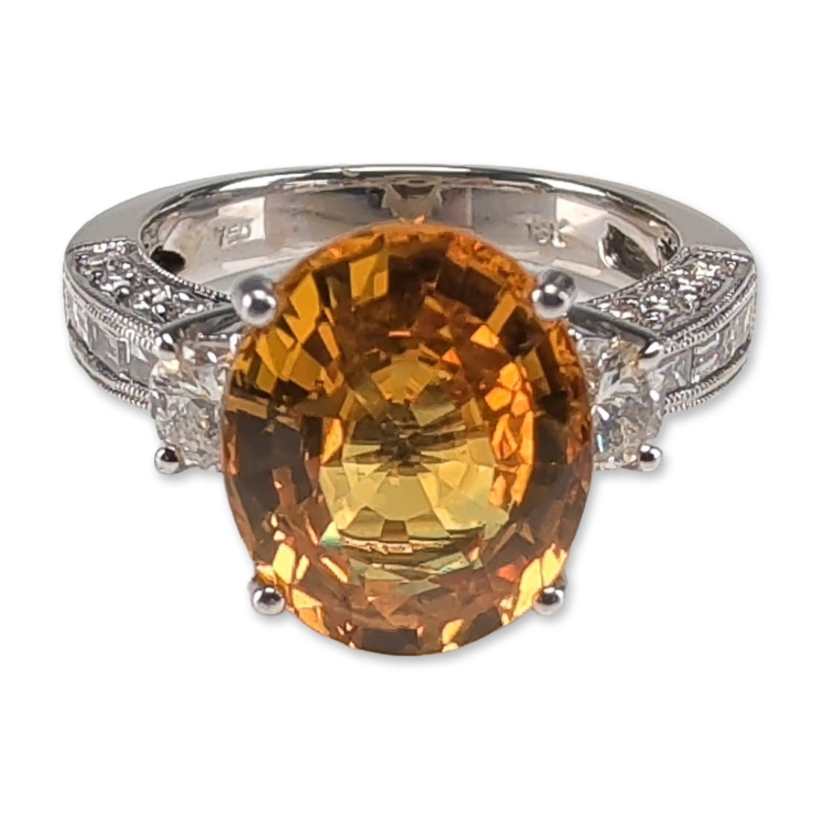 18K White Gold 5.50ct Oval Orange Sapphire and Diamond Ring: 18K white gold ring featuring a prominent oval-cut vibrant orange sapphire, secured in a four-prong setting and weighing 5.50 carats. The center stone is flanked by two half moon cut diamonds. The sho