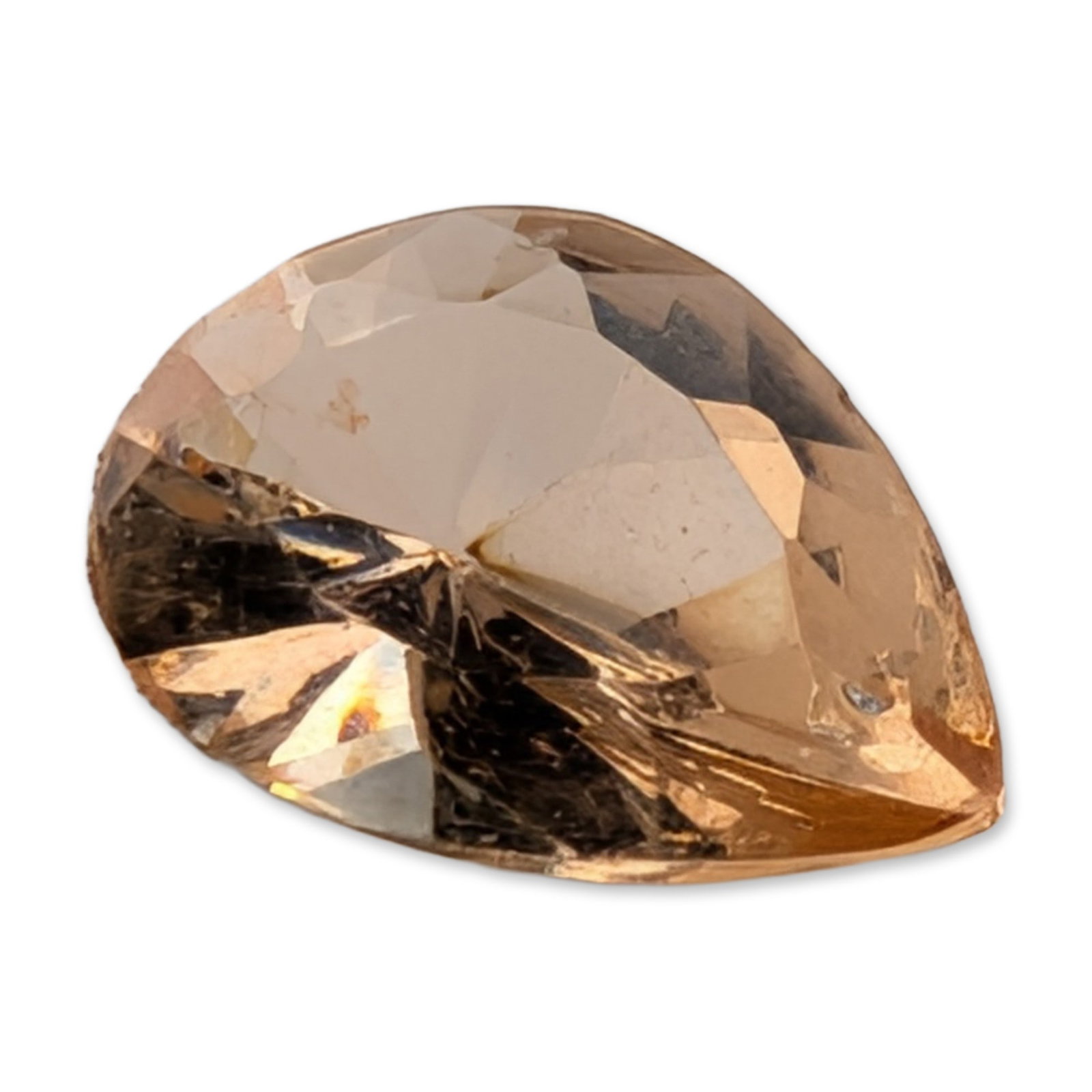 Pear Cut Peach Tone Loose Zircon Gemstone: Faceted loose zircon gemstone in a pear cut, featuring a pale peach-pink to champagne hue. The stone is cut with a large table and multiple crown and pavilion facets. Minor internal feather