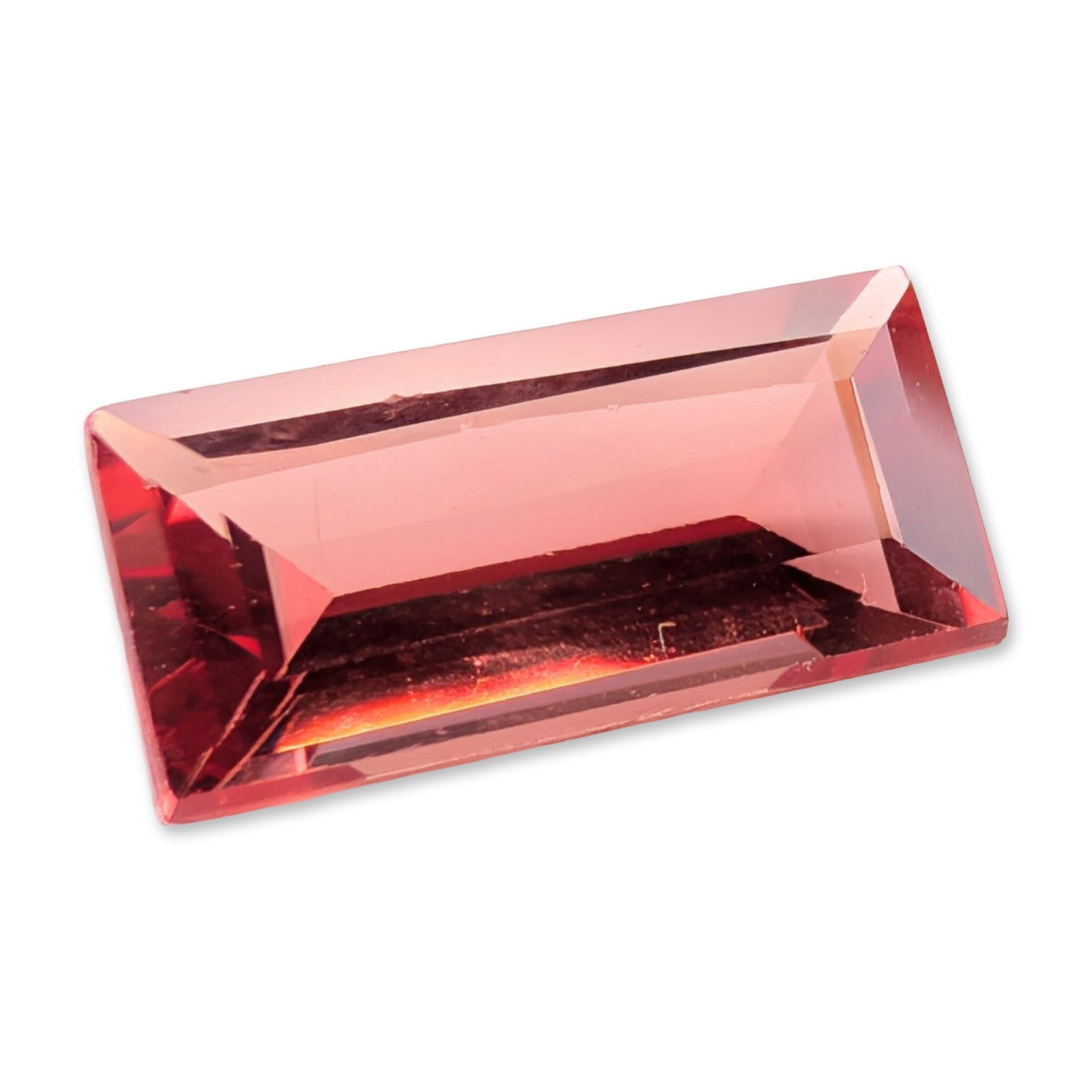 Rectangular Step Cut Salmon Pink Loose Tourmaline Gemstone: Loose tourmaline gemstone featuring a rectangular step cut in a salmon-pink hue with secondary orange undertones. It displays high clarity with no apparent internal inclusions visible to the naked