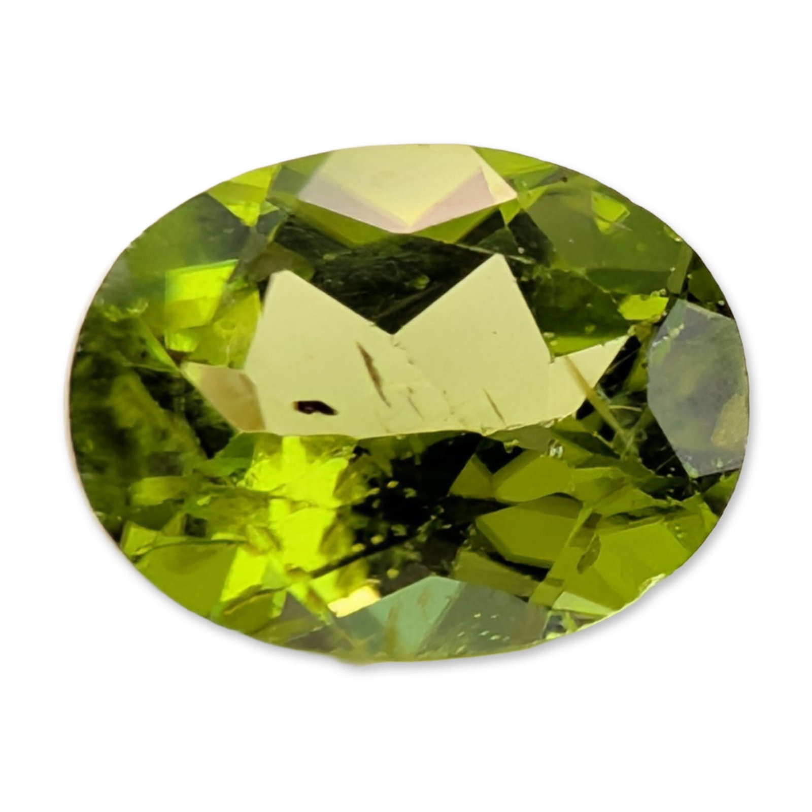 Oval Mixed Cut Peridot Gemstone: A peridot gemstone in an oval mixed cut. The stone displays a saturated yellowish-green hue characteristic of the species. Internal features include visible dark crystal or needle-like inclusions and