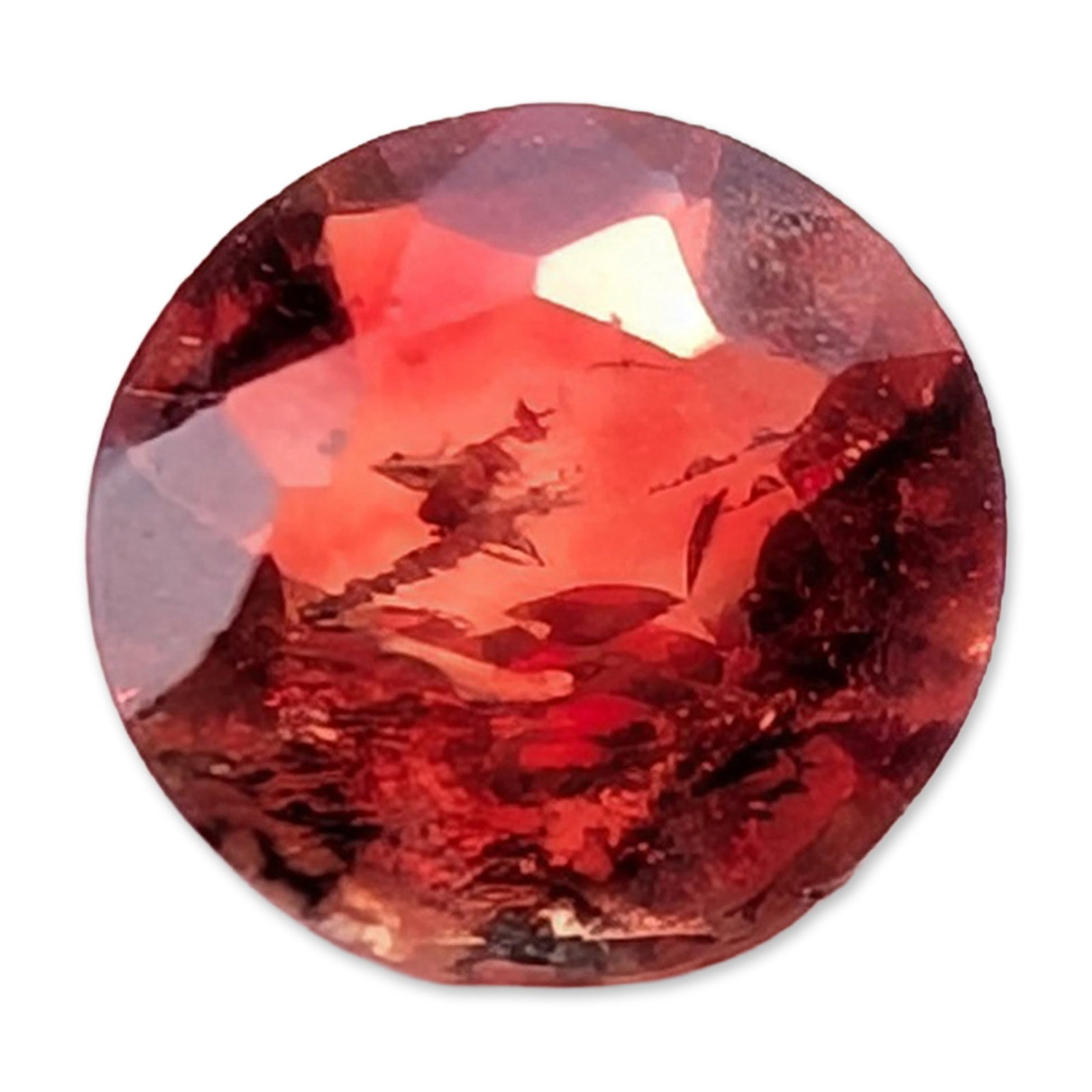 Faceted Round Orange-Red Gemstone: Faceted round orange-red gemstone in a brilliant cut, weighing approximately 0.6 carats, featuring internal crystalline inclusions and veils. 5.4 mm. Dimensions: 5.4 mm