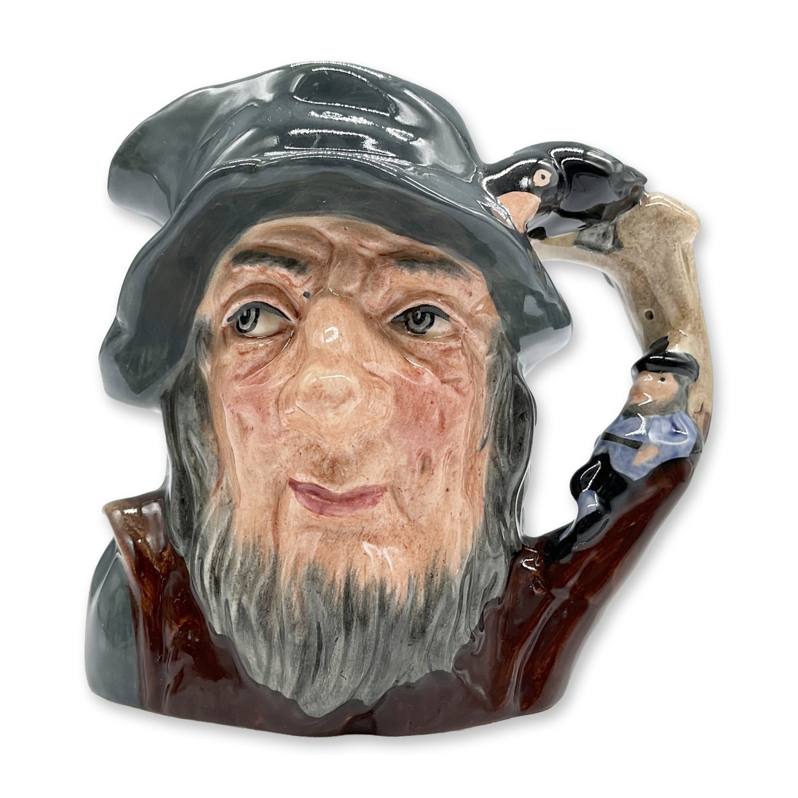 Rip Van Winkle D6463 - Small - Royal Doulton Character Jug: Variation One. Grey-blue cap; brown robes; figure dressed in blue resting against a tree. Royal Doulton backstamp. Artist: Geoff Blower Dimensions: 4"H Date or Era: 1957 - 1995 Manufacturer or Brand: 