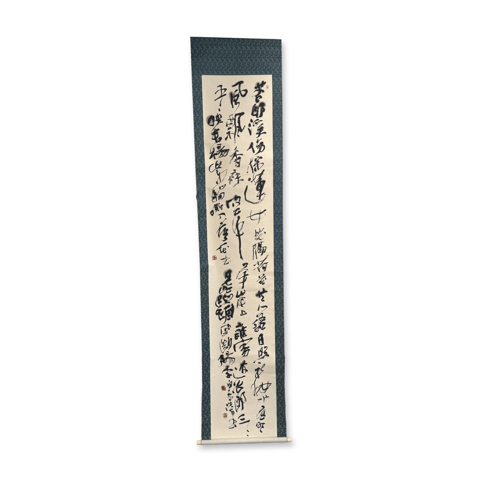Chinese Ink on Paper Cursive Calligraphy Hanging Scroll Signed w/ Seal: Chinese hanging scroll in ink on paper, featuring a poem in a fluid wild cursive script. The work is mounted with a blue floral motif silk-style fabric border and backed with cream paper. The calligra