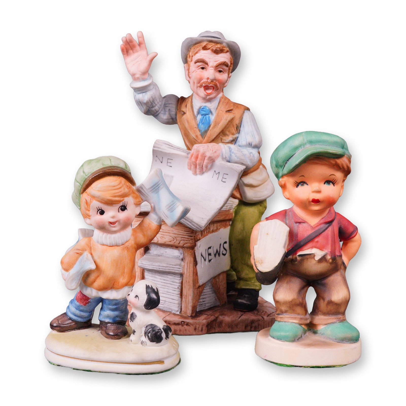Three Mid-to-Late 20th Century Painted Ceramic News Vendor and Newsboy: A group of three painted ceramic figurines depicting a street scene centered around a newsstand. The central figure portrays an adult news vendor in a hat and vest, gesturing, standing behind a newsst
