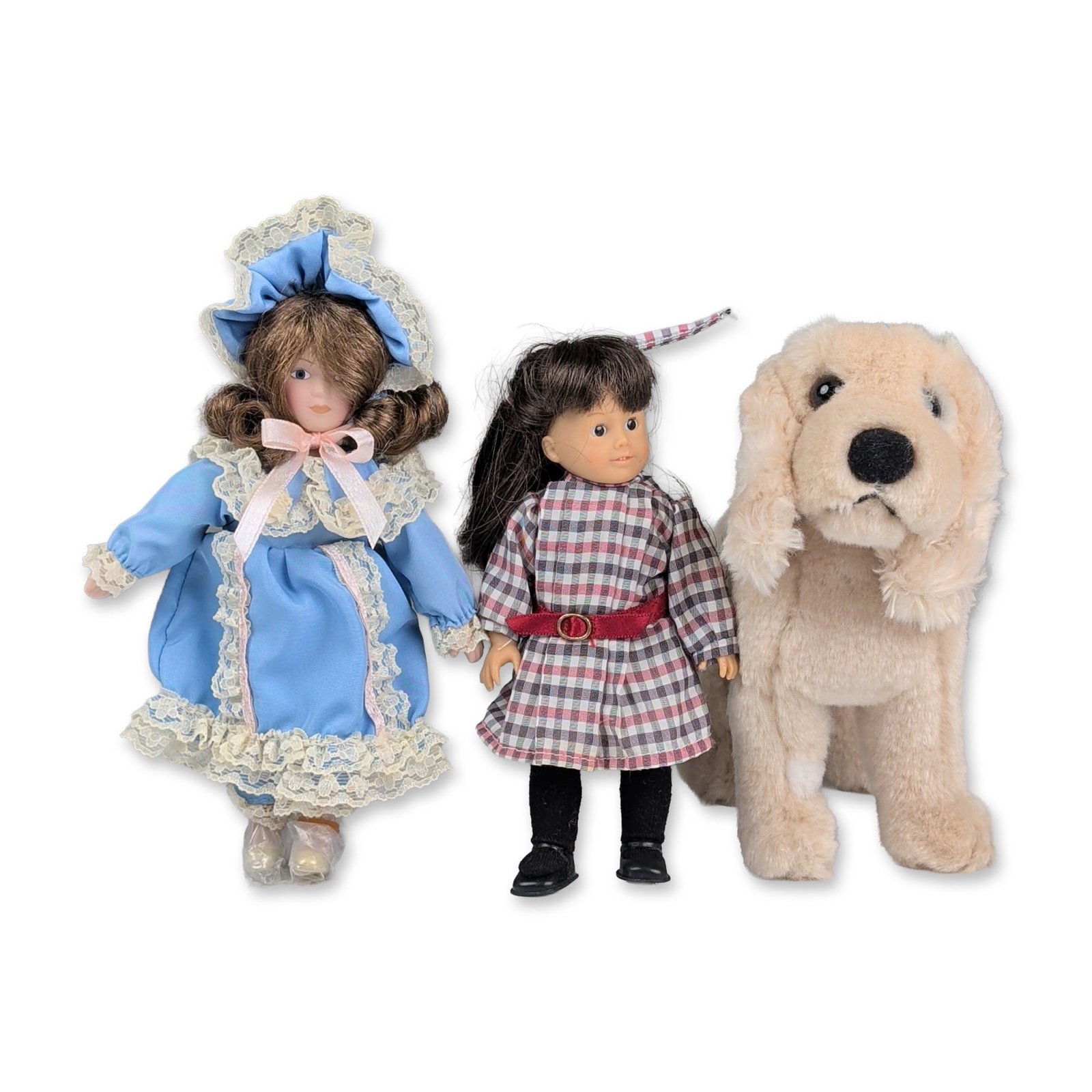 4pc American Girl Doll, Toy Dog, and Doll with Stand: Three items including a vinyl mini doll, a plush dog, and a bisque porcelain fashion doll. The mini doll features dark brown hair with bangs, inset dark eyes, and a plaid dress with a red sash and gol