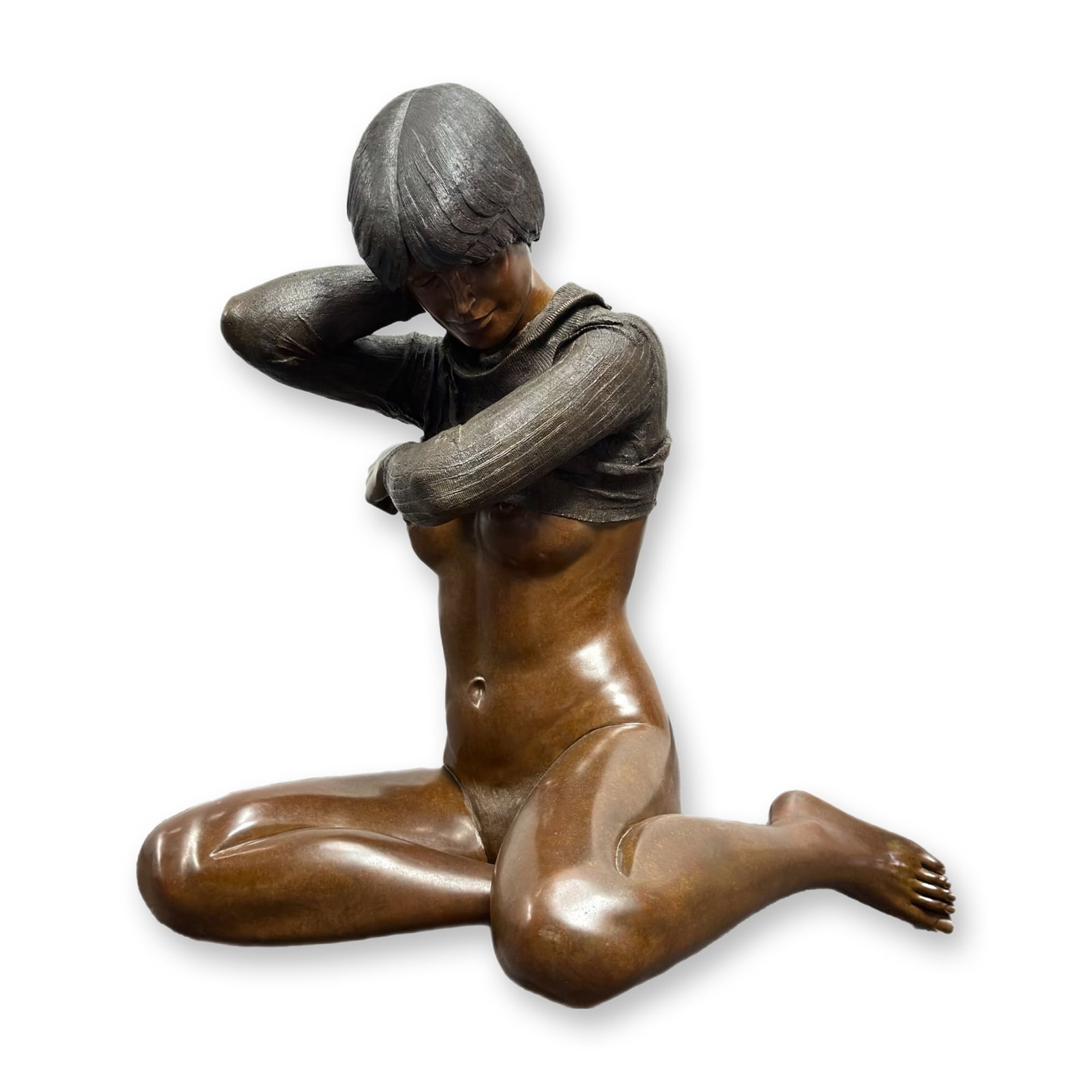 Isidore Margulies Bronze Sculpture Debbie 1979 Edition 4 of 12: This bronze sculpture by Isidore Margulies (Austrian/American, 1921-2008) is titled Debbie and dated 1979. The modern realist work depicts a seated female figure in the act of pulling a ribbed sweater