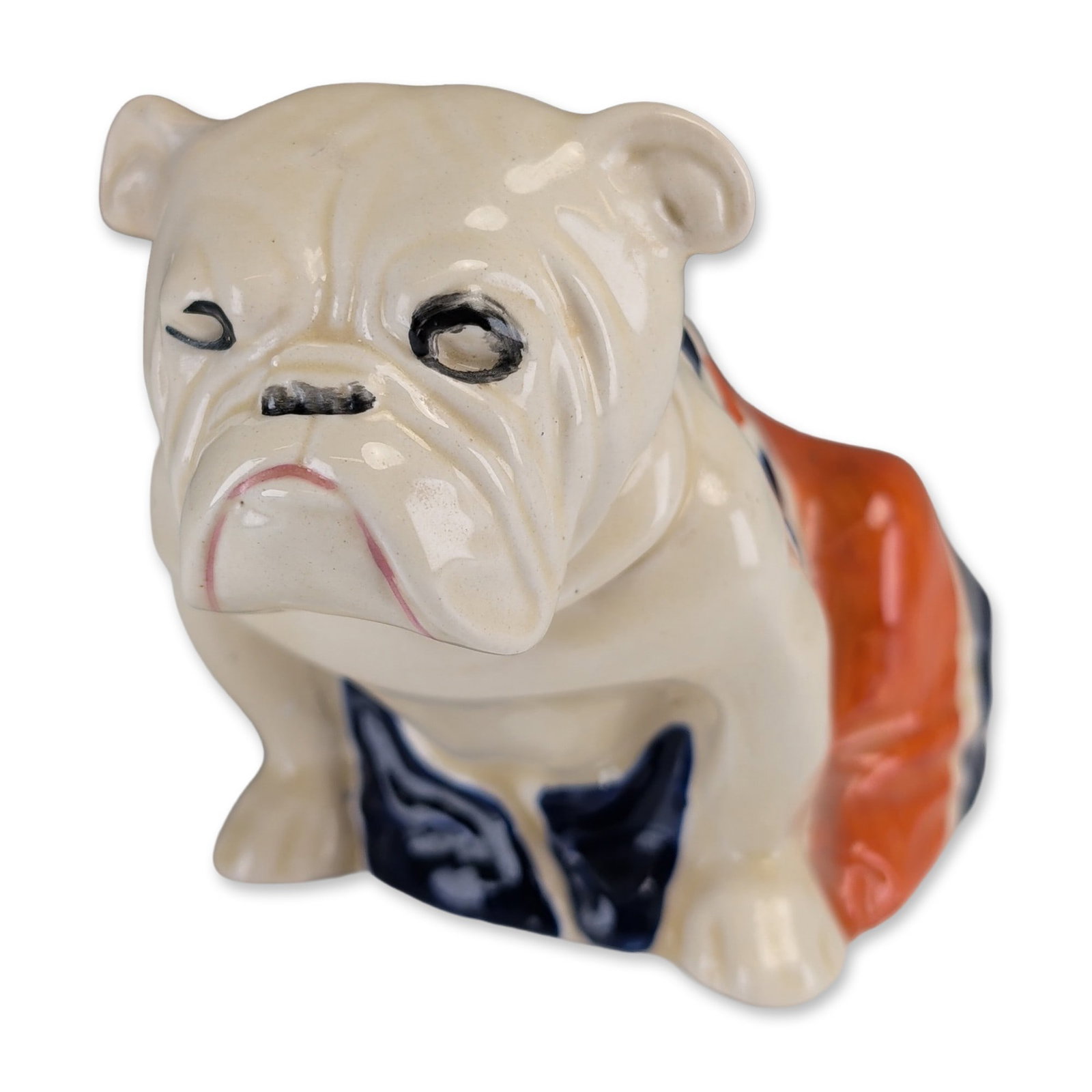 Royal Doulton Union Jack Bulldog Porcelain Figurine: Royal Doulton, England, glazed porcelain figurine of a seated bulldog draped in a Union Jack flag. The dog is modeled with a cream-colored body and a black-buckled collar, featuring hand-painted black