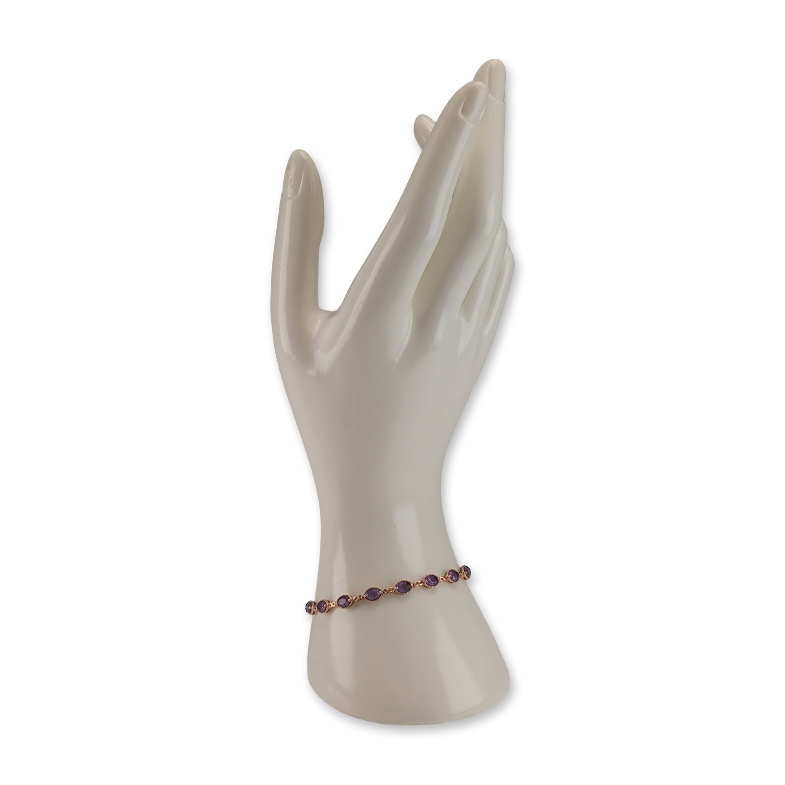 14K Rose Gold and Amethyst Infinity Link Bracelet: A 14K rose gold infinity link bracelet set with seventeen oval-cut amethysts. Each gemstone is housed in a two-prong setting with a decorative beaded border. Each setting is connected by small infinit