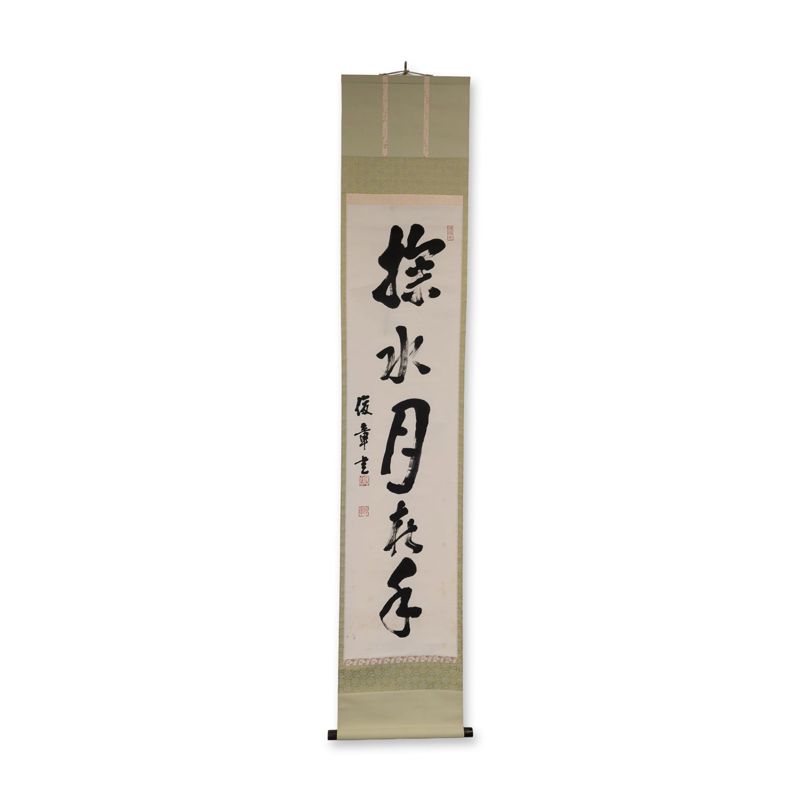 Japanese Ink on Paper Calligraphy Hanging Scroll: Japanese hanging scroll in ink on paper featuring four large characters in bold semi-cursive calligraphy. The work is mounted on a traditional green floral silk brocade. The signature is located at th