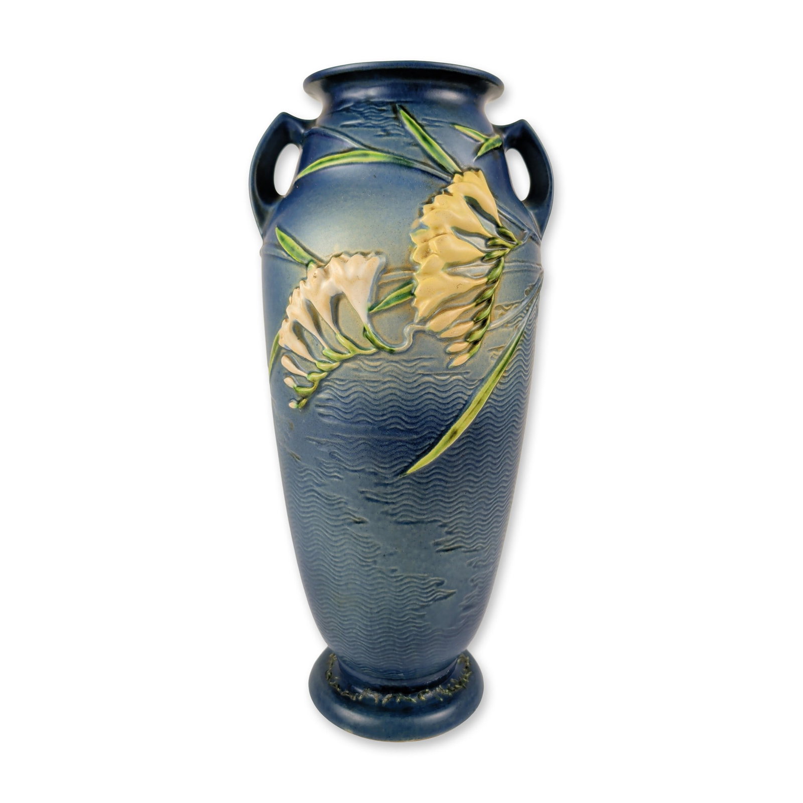 Roseville Pottery Freesia Blue Floor Vase: Roseville Pottery earthenware floor vase in the Freesia pattern, shape number 129-18. The tall, tapered vessel features relief-molded clusters of freesia blossoms in shades of yellow and white with gr