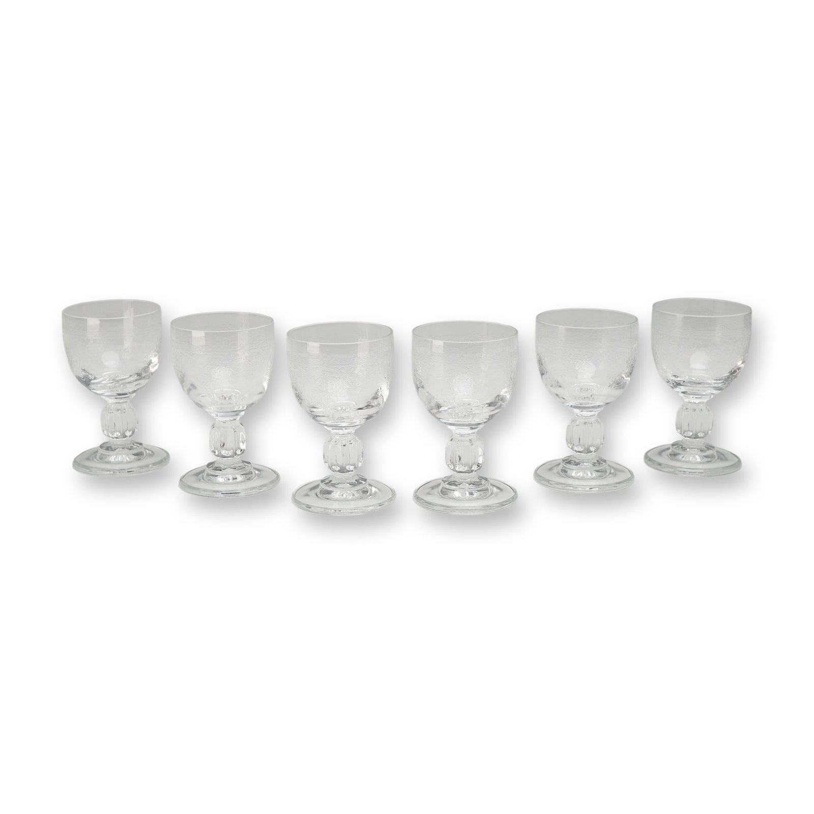 6pc Floral Etched Cordial Glasses: A set of six stemmed cordial or liqueur glasses manufactured from lead crystal. The bowls are decorated with fine etched ornamentation featuring a narrow geometric band of cross-hatching at the rim an
