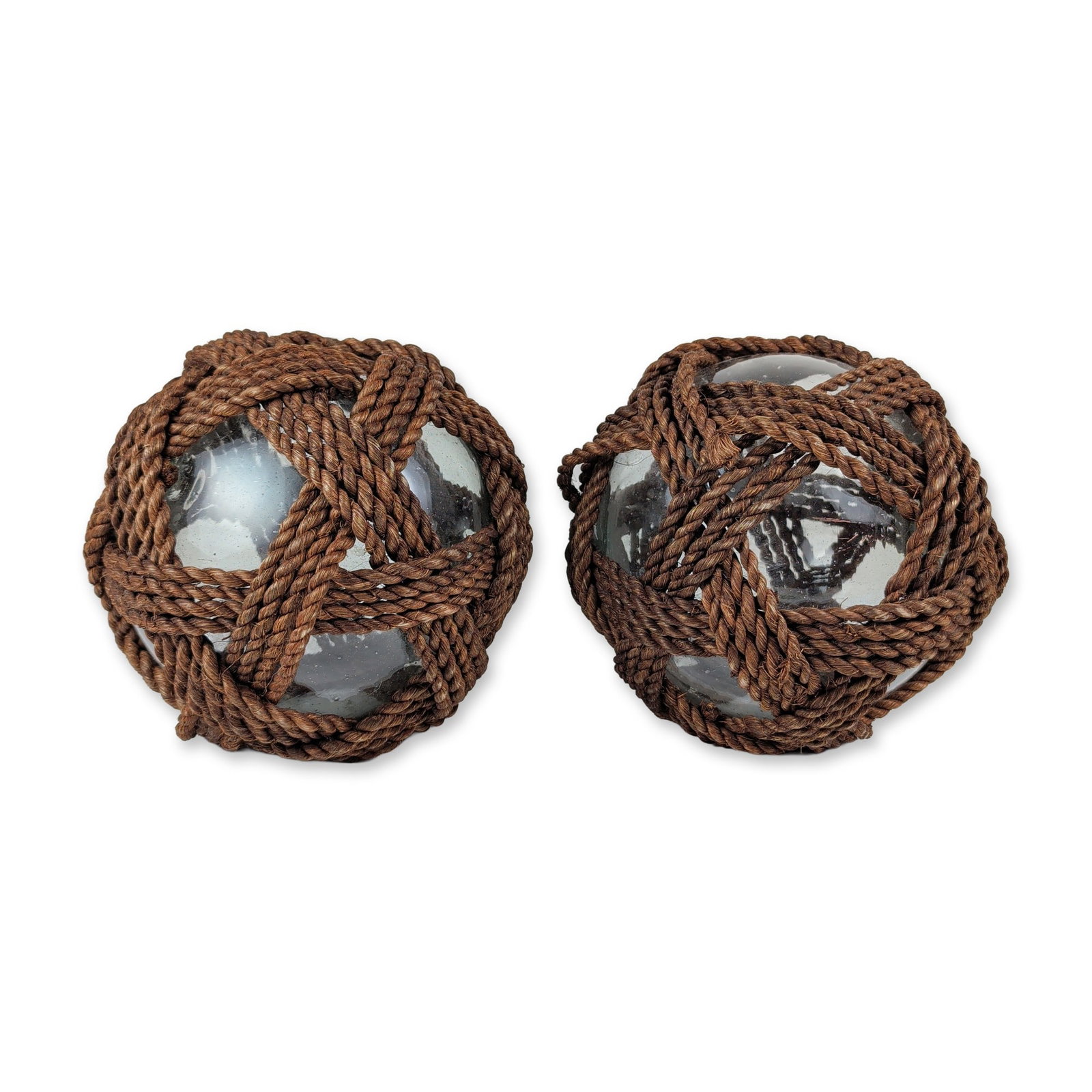2pc Hand Blown Glass Fishing Floats: Decorative nautical glass floats in hand-blown clear glass with brown rope netting. The spheres feature a slight smoky tint and internal seed bubbles characteristic of traditional hand-blown productio