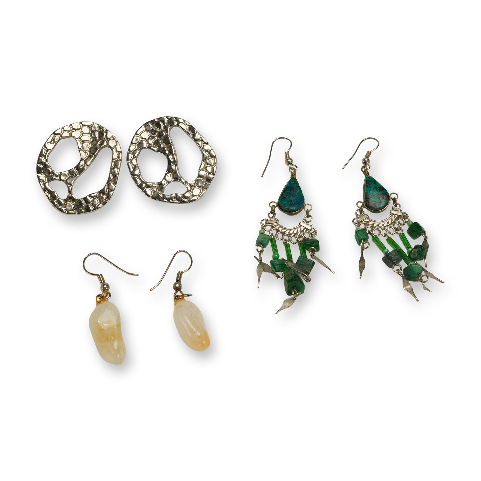 A Collection of Three Pairs of Assorted Costume Earrings: A collection of six individual earrings, forming three distinct pairs of costume jewelry. The first pair consists of large, abstract, openwork stud or clip-on earrings crafted from silver-tone metal, 